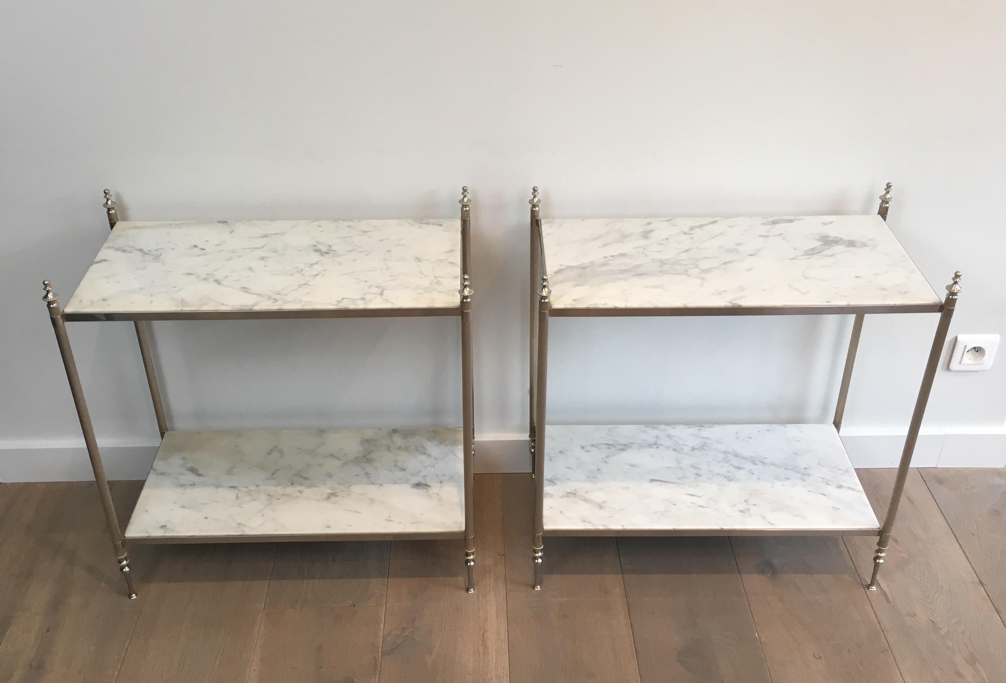 This rare and beautiful neoclassical pair of side tables is made of silvered metal with 2 very nice Carrara marble tops. These end tables are French, in the style of famous French designer Maison Jansen, circa 1940.