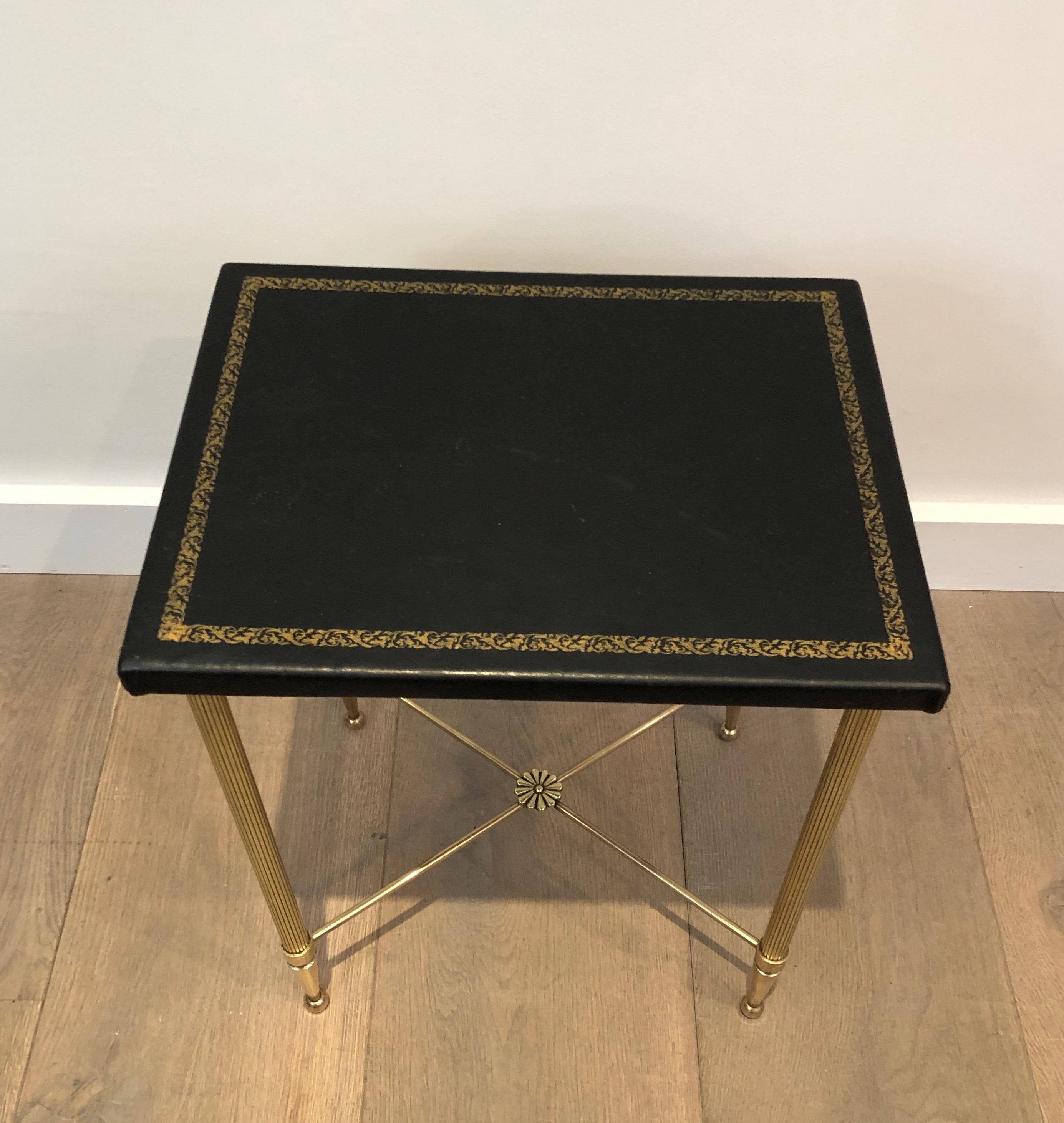 This small side table is made of brass and gold-trimmed leather. This is a French work, in the style of Maison Jansen, circa 1940.