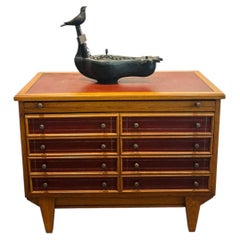 In the style of Maxime Old, small wood and leather chest of drawers.