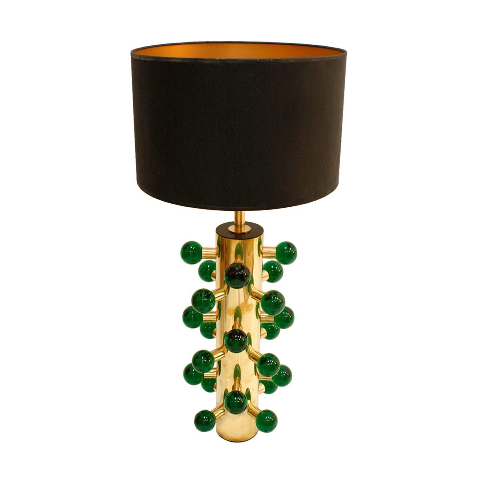 Contemporary maximalist pair of brass table lamps, a stunning blend of modern design and opulence. This exquisite lamp features a cylindrical Polished brass structure adorned with spherical Murano colored in green glass pieces, adding a touch of