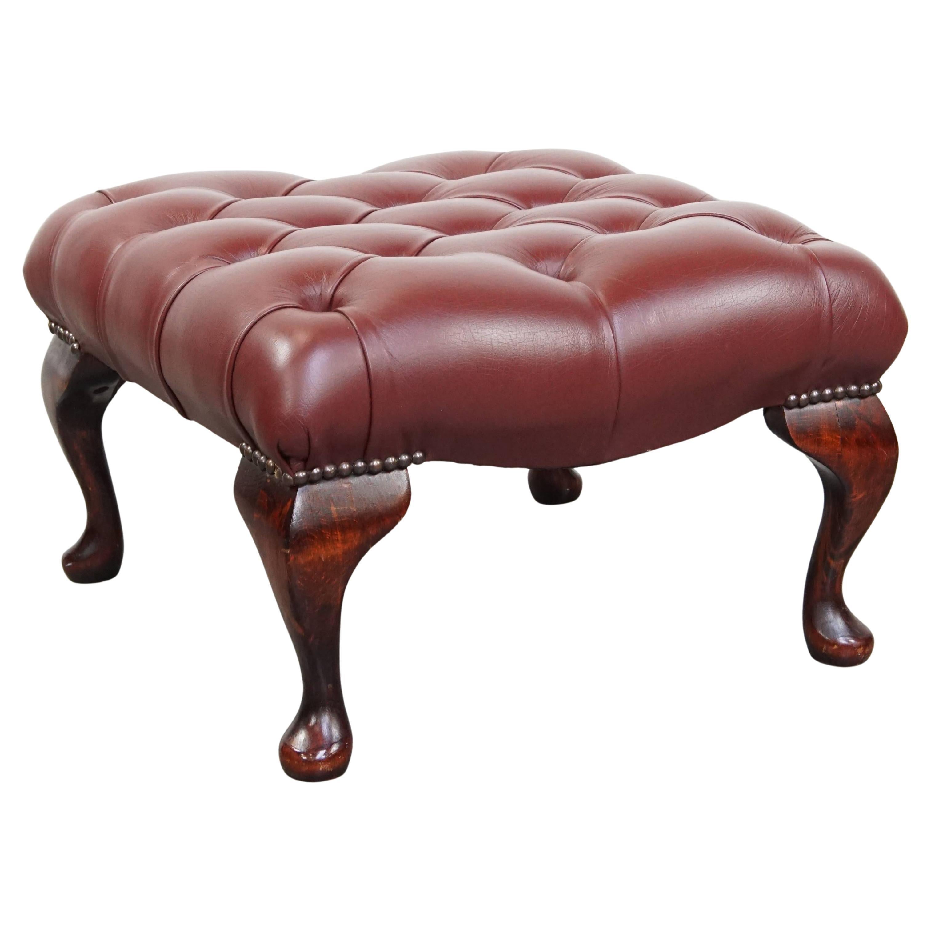 En très bon état, élégant pouf en peau de vache Chesterfield rouge/marron.