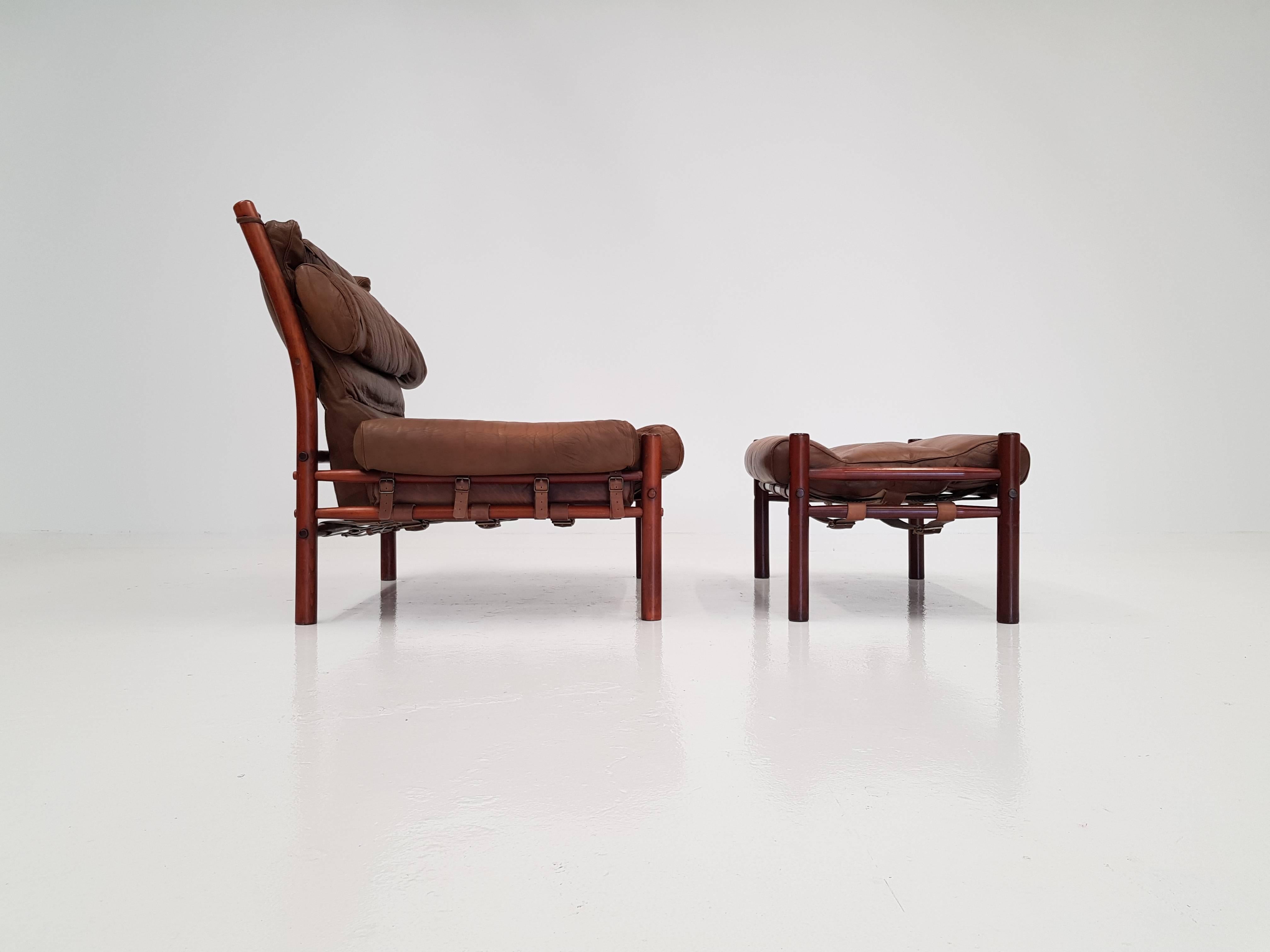 An iconic Inca chair and footstool by Swedish designer Arne Norell for Norell Möbler. An extremely comfortable chair which also looks amazing. The piece is in good vintage condition.

Consists of a stained beech frame with leather seat pads in a