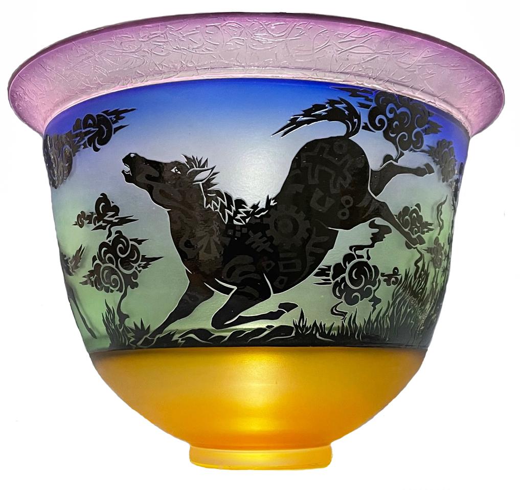 This cameo etched bowl by Gary Genetti is incalmo and overlay blown glass. The original artwork is drawn, hand cut then pressure etched through layers of color to create the imagery. The piece consists of sections of layered colored glass partially