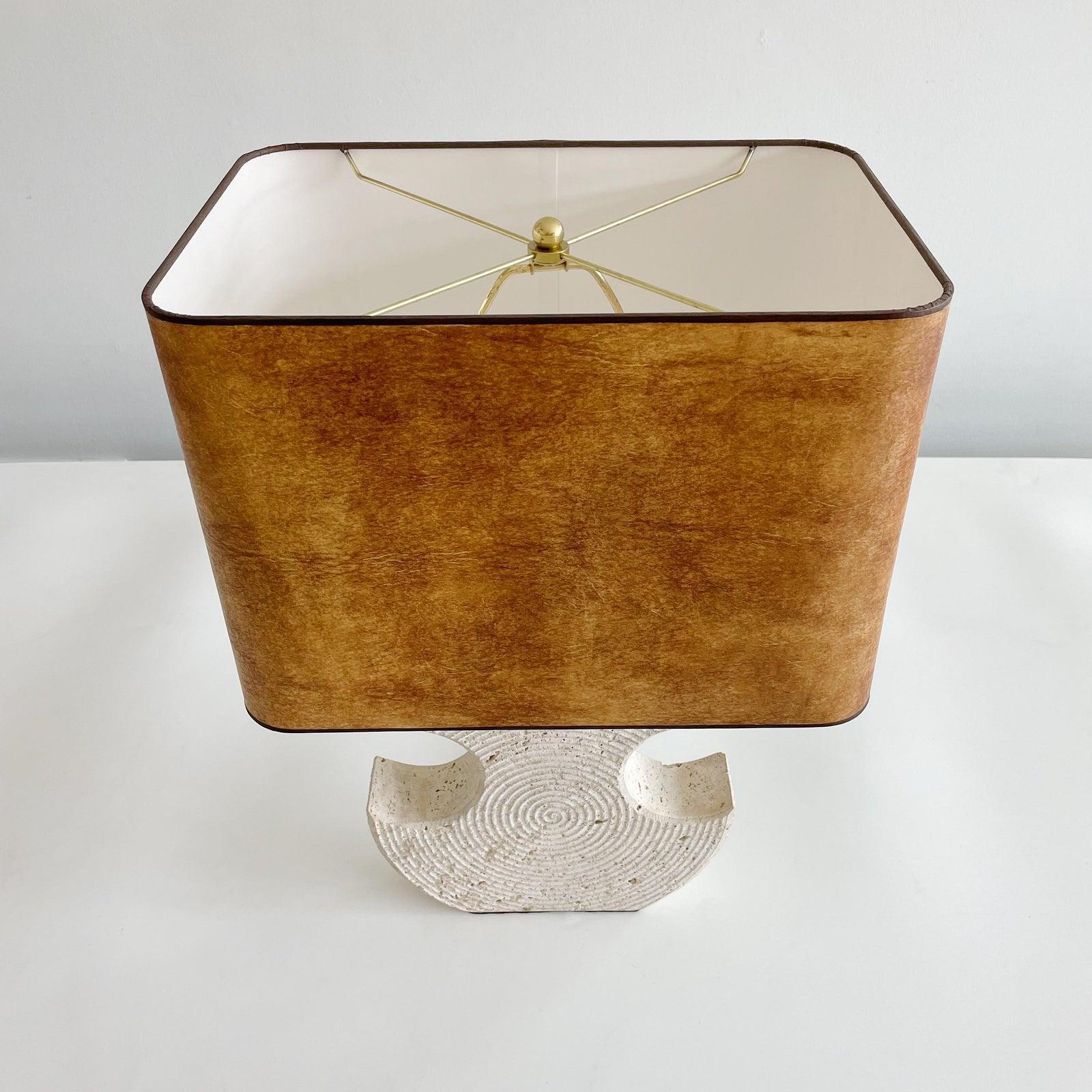 Solid Italian travertine lamp with circular incised pattern on both sides. Newly professionally rewired with bronze silk cord and new brass fittings. Comes with Leather shade. which measures 16 wide x 11 deep x 11 High. Height of actual travertine