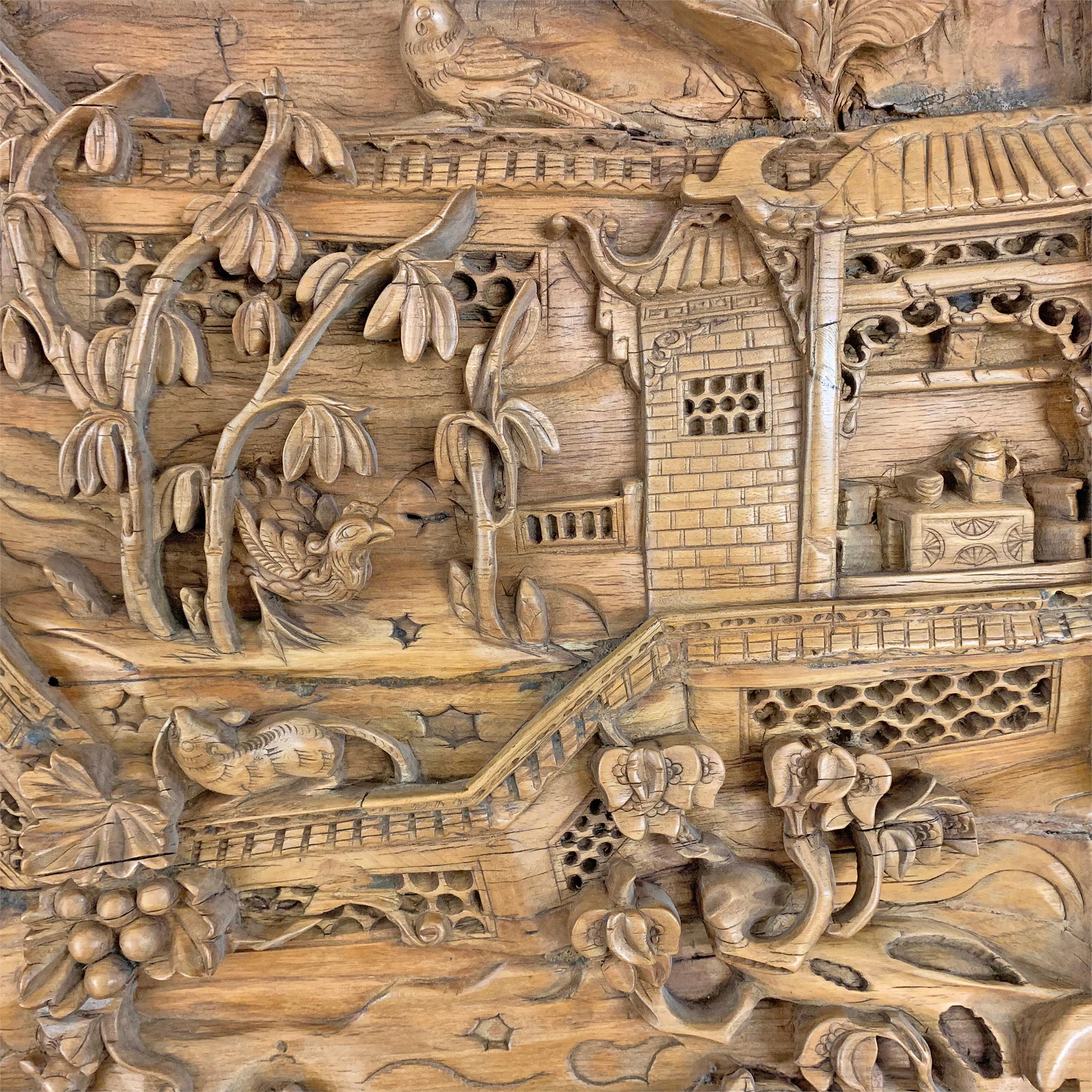 An incredible 19th century Chinese wooden architectural panel carved in high relief depicting a walled courtyard scholars garden with multiple pavilions and a bridge amidst auspicious flowering trees and a lotus pond, with various bulls, mice, and