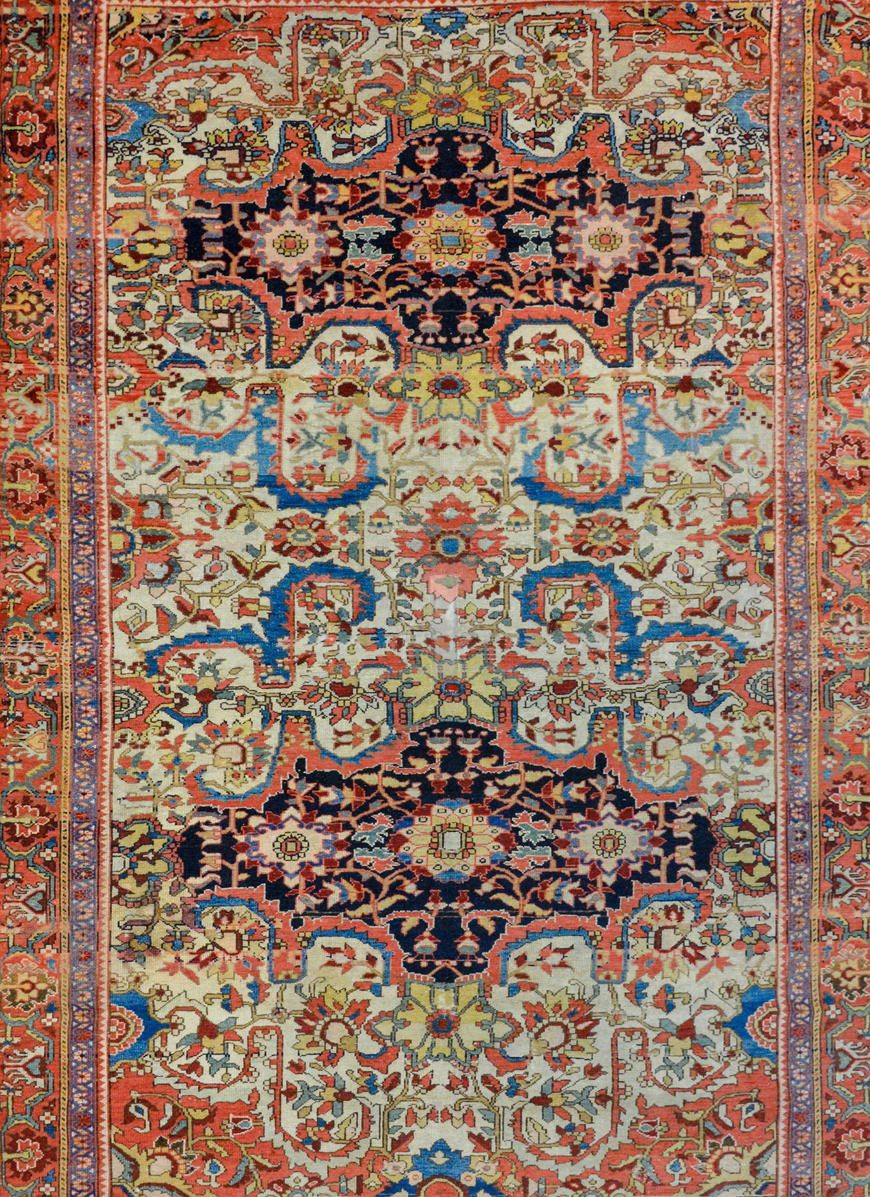 An incredible 19th century Persian Mission Malayer rug with a wonderful pattern containing two large floral medallions against a dark indigo background amidst an intensely woven field of more flowers and scrolling vines woven in myriad colors