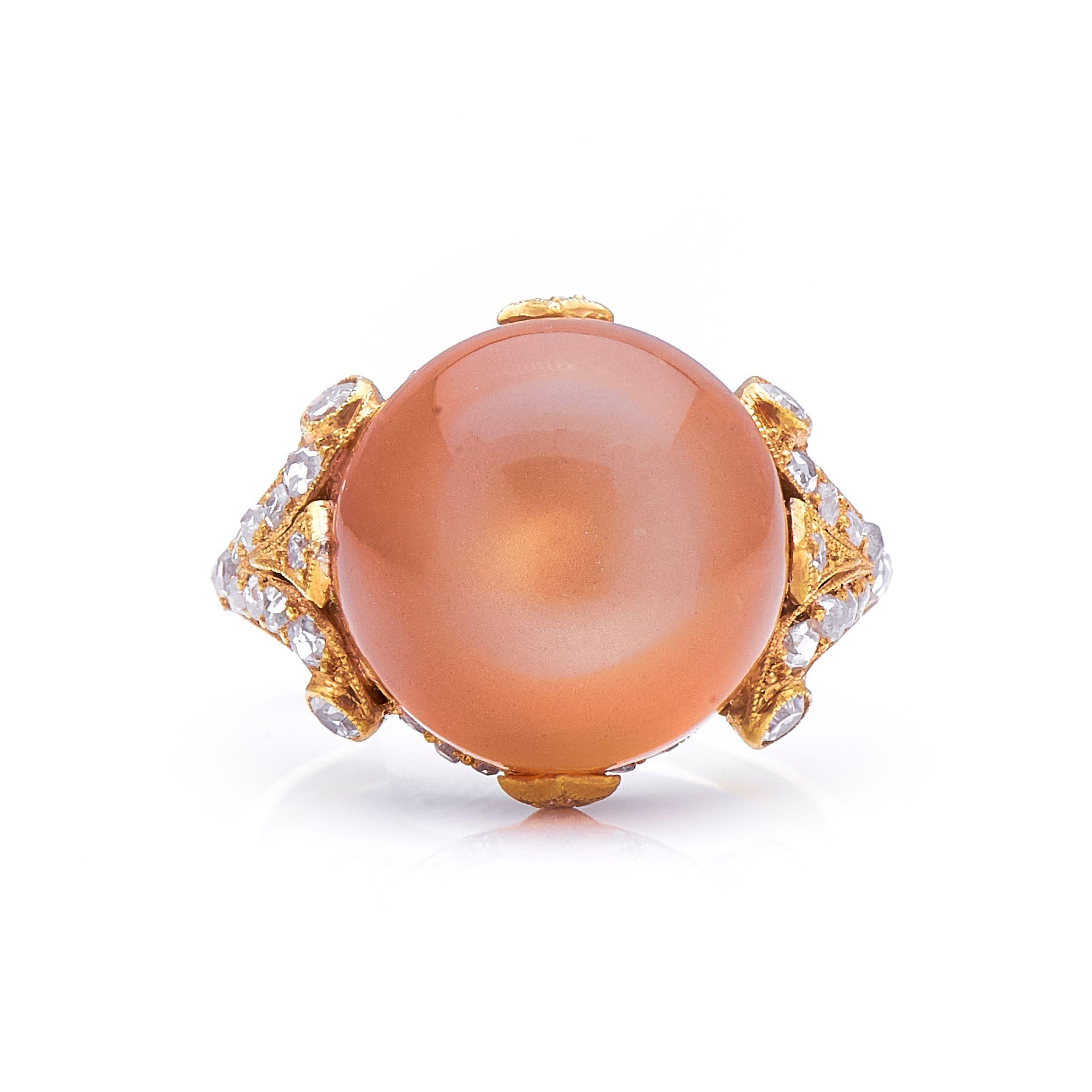 Moonstone and diamond ring, circa 1910. At the heart of this ring is a wonderful peach coloured moonstone with a characteristic white sheen, held in a finely millegrained mount in warm yellow gold with delicately scrolled shoulders. The distinctive