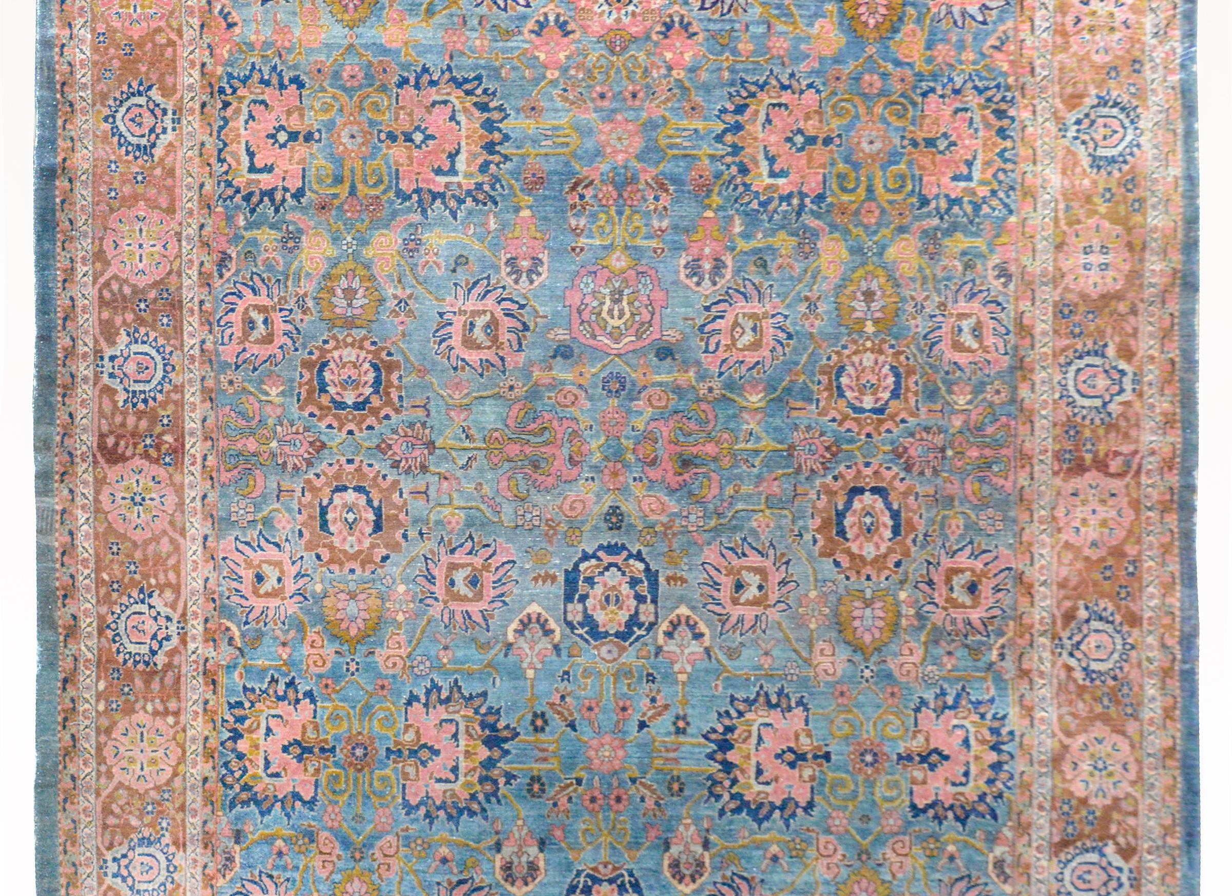 An incredible early 20th century Sultanabad rug with a beautiful all-over large-scale floral and scrolling vine pattern woven in bold colors including light and dark indigo, pink, turquoise, and burnt orange. The border is beautiful, and woven with