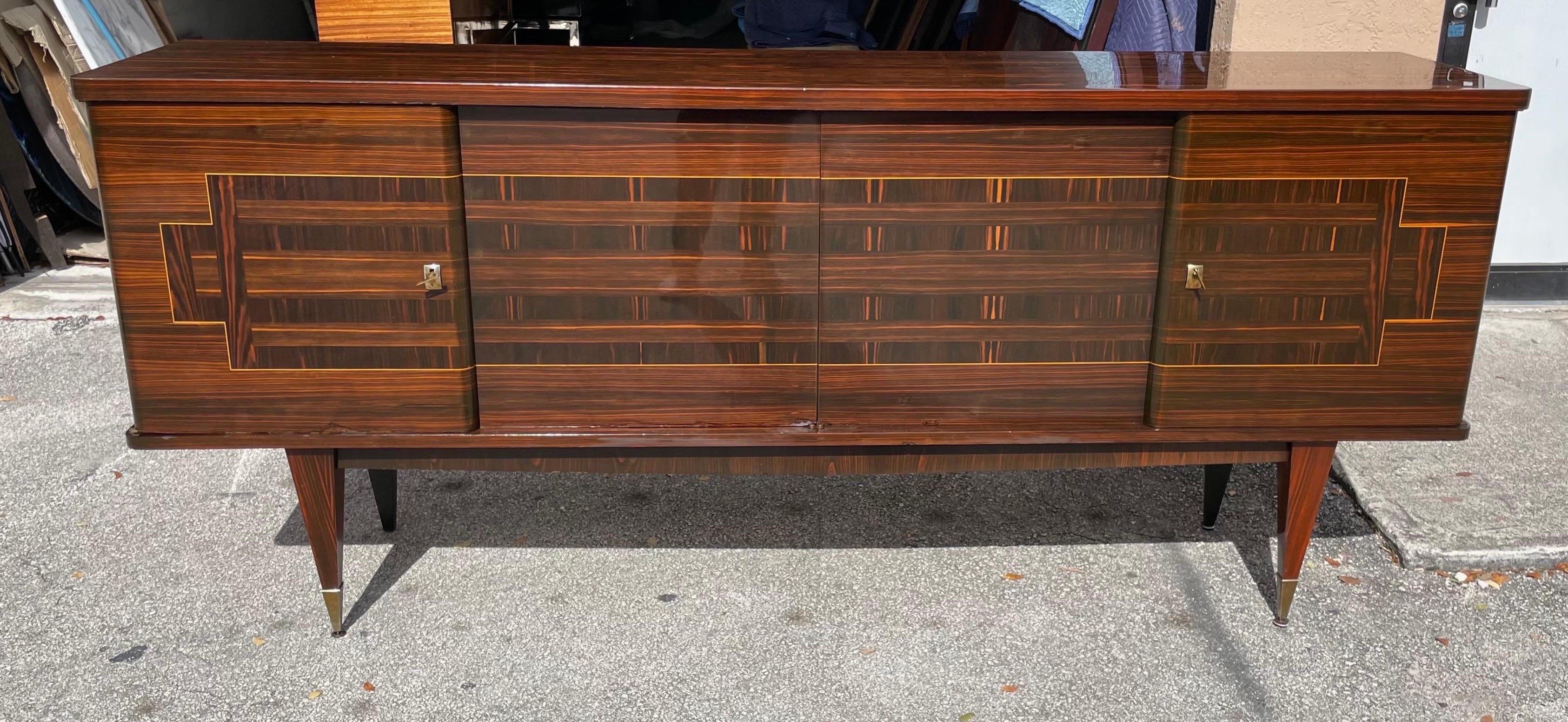 Incredible French Art Deco 4 door exotic Macassar ebony credenza or sideboard. The sideboard opens to reveal removable shelves and a bar.