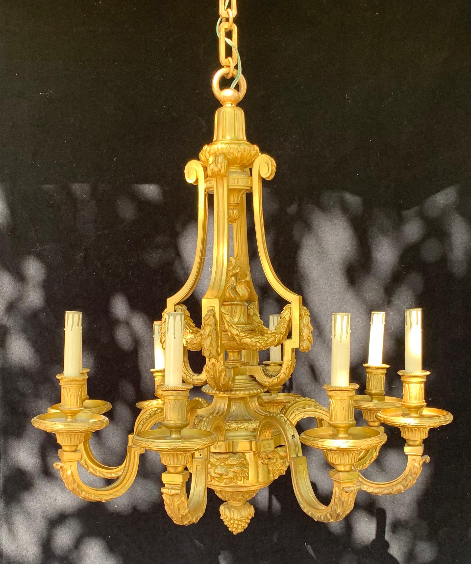 An incredible French doré bronze neoclassical lion mask and urn chandelier with filigree tassels in the manner of Henri Vian with 8 candelabra sockets ready to install and enjoy.
We have the larger version of this exact chandelier in our gallery,