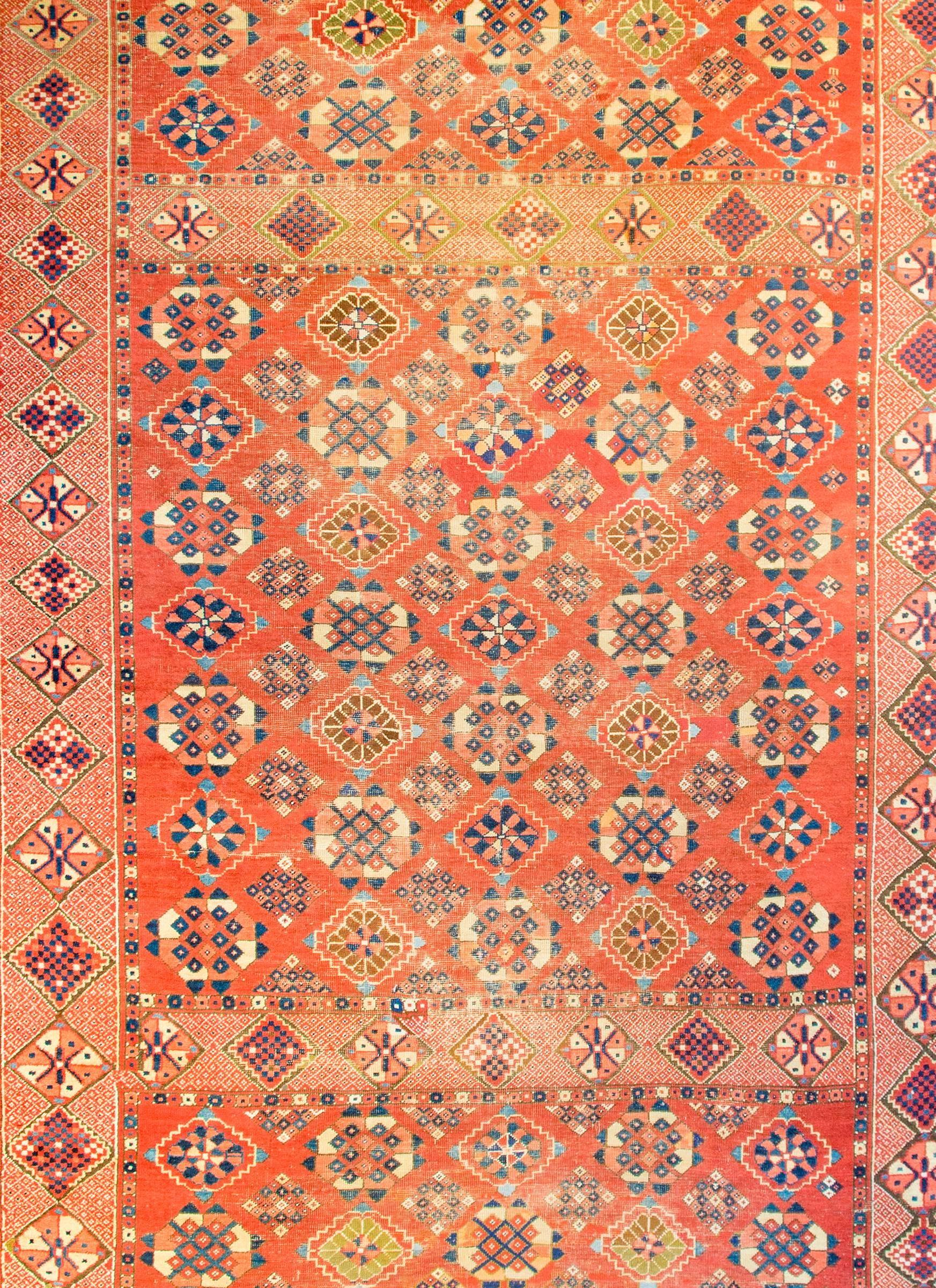 An incredible late 19th century Afghani Bashir rug with an unbelievable and intricately woven pattern containing all-over stylized flowers woven in indigo, gold, green, and salmon colored wool, on a bright crimson background. The border is wide with