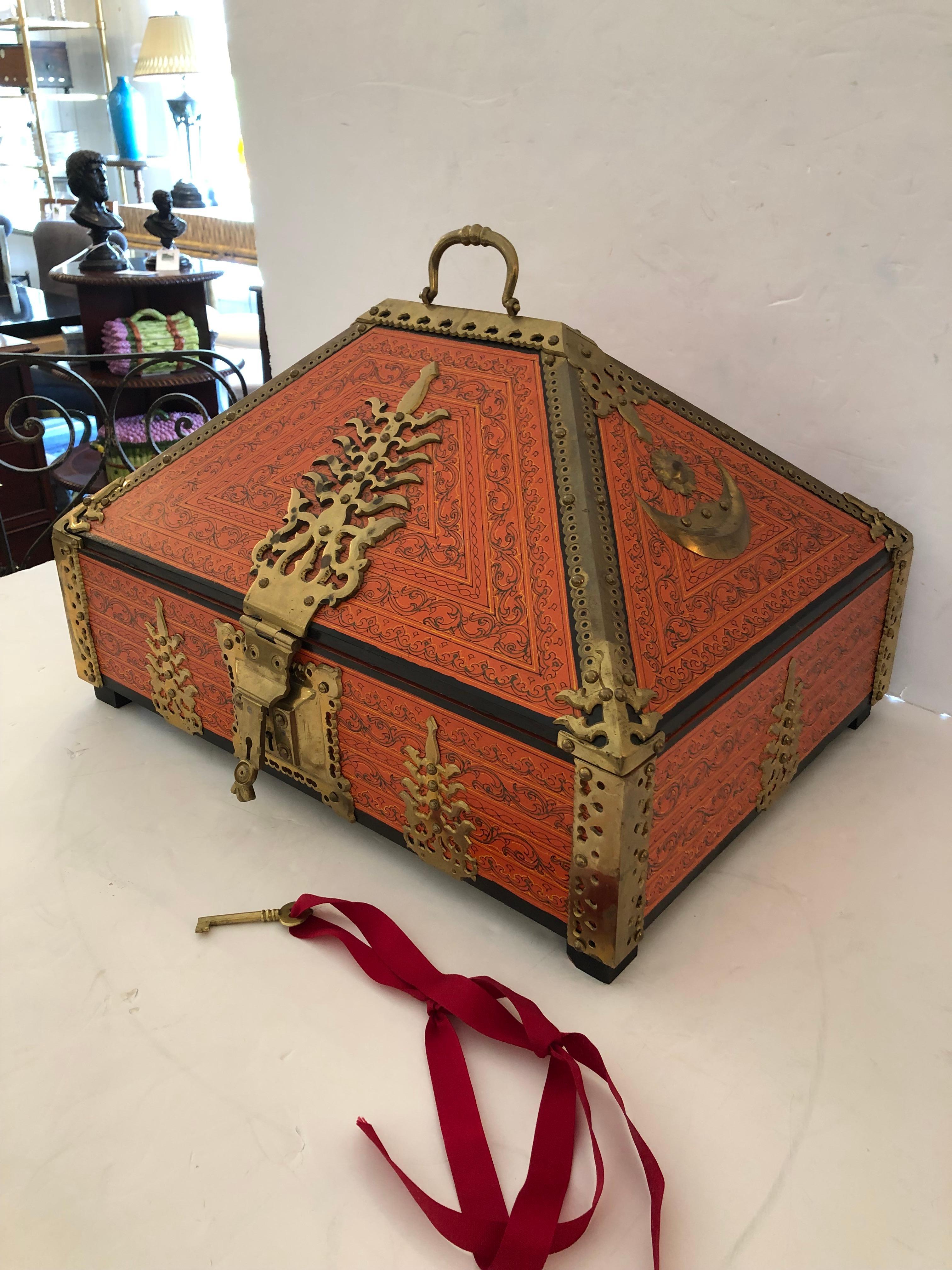 Incredible eye catching decorative box having meticulous decoration painted against a striking Hermes orange background. Stunning brass hinges, lock and key, sun and moon adorn the box. The more you look, the more details are revealed. Box opens to