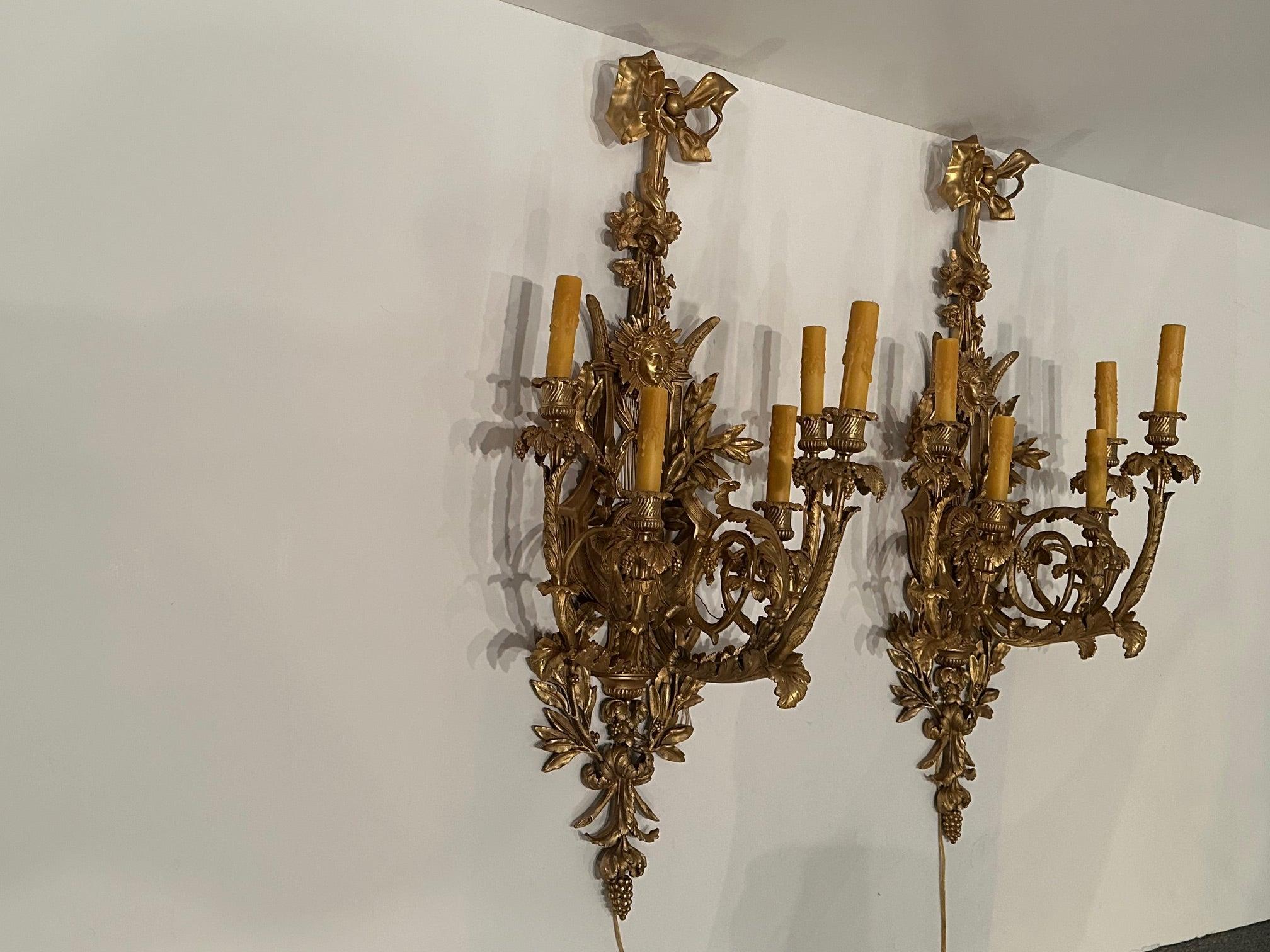 Sublime paire monumentale d'appliques vintage en bronze doré de style Belle Epoque à la décoration fantaisiste comprenant des lyres, des feuillages et une tête figurative d'Apollo entourée de rayons de soleil.  5 bras par applique.