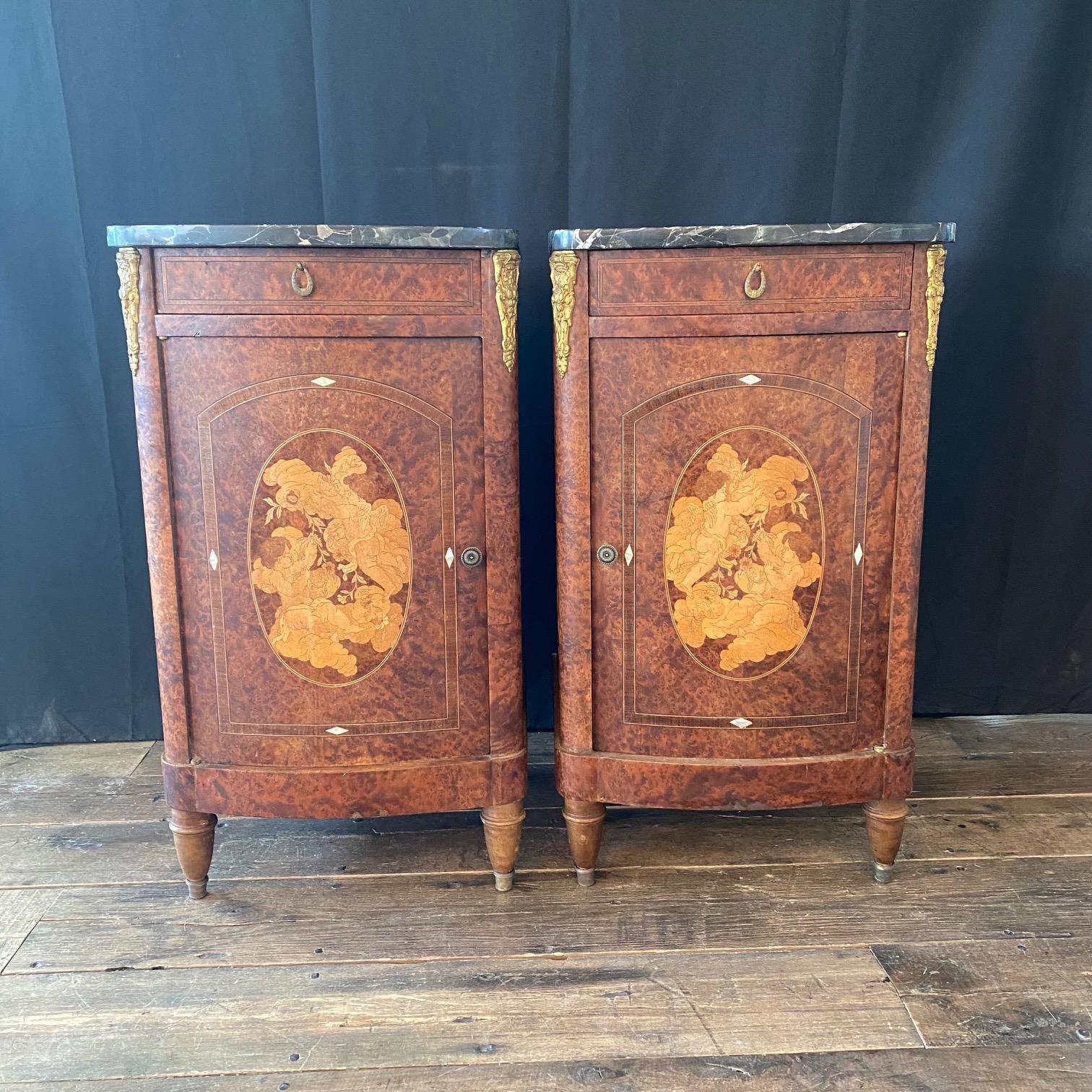 Stunning pair of antique French burlwood inlaid marble top night stands having single drawer and lower cabinet door with upper and lower shelves inside. The interior of the lower shelf is lined with its original white carrara marble (one of the