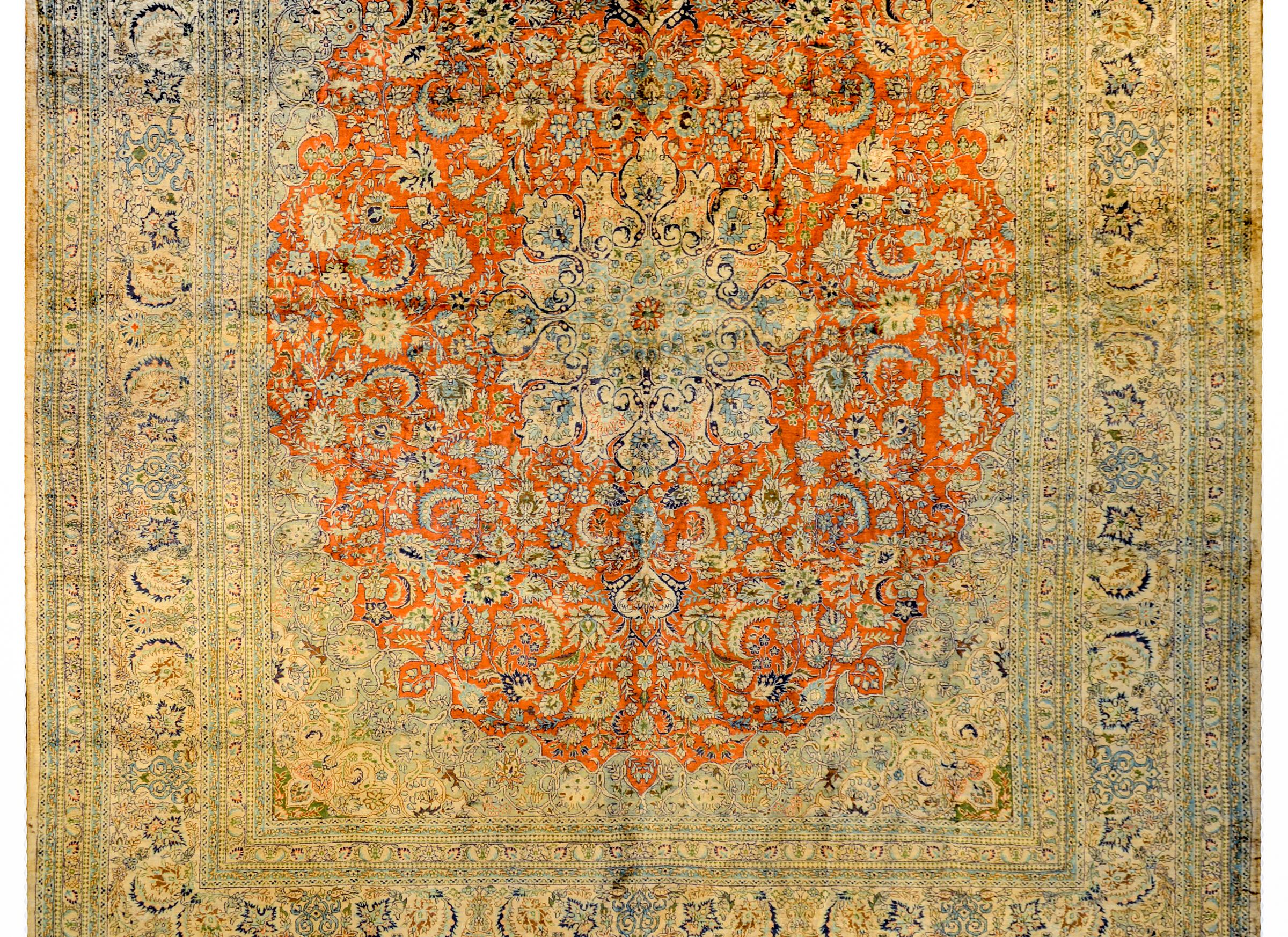 An incredible mid-20th century Indian 100% silk Isfahan rug with a fantastic large scale central sixteen-lobed floral medallion amidst a burnt orange field of myriad flowers and leaves. The border is unmatched in excellence with dozens of thinly