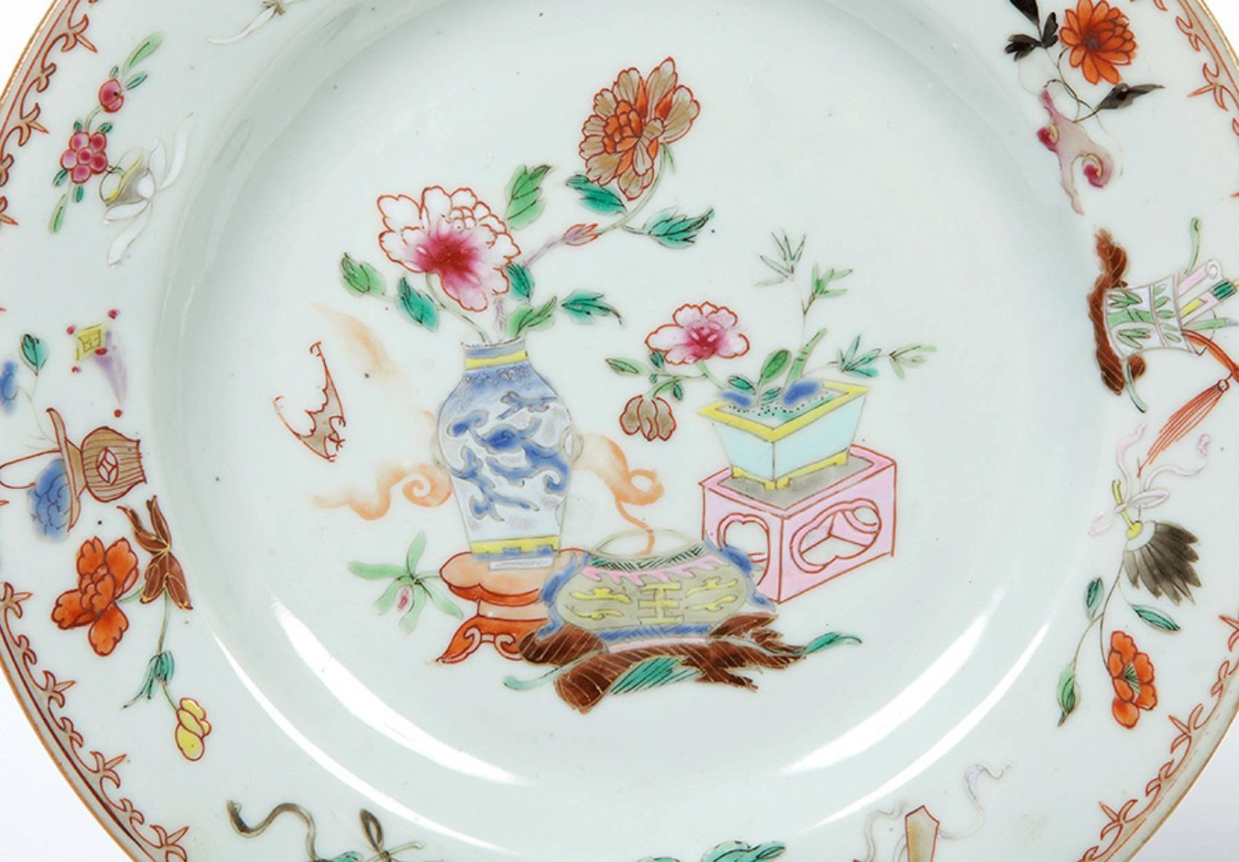 Pair of enameled porcelain dishes, made in China for export to Europe. They present enameled decorations in high and low temperature colors, in the Pink Family style, representing flowers, instruments of the table of the learned and vases. The Rosa