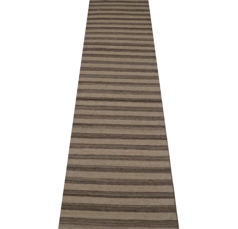 Scopri l'eleganza del Rug & Kilim dell'India, caratterizzato da un tappeto runner del 1990. Progettato in lana e marrone-avorio, questo design esclusivo è perfetto per valorizzare il tuo spazio.