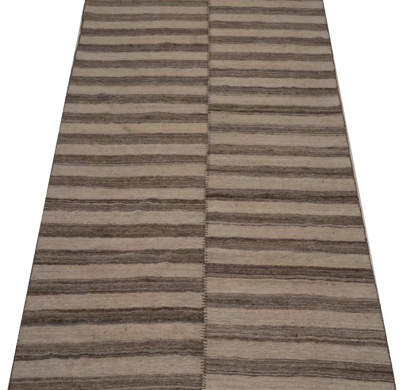 Entdecken Sie die Eleganz des indischen Kilim mit dem kleinen Teppich von CIRCA 1990. Dieses exklusive Design aus Wolle und Braun-Elfenbein ist perfekt, um Ihren Raum zu verschönern.