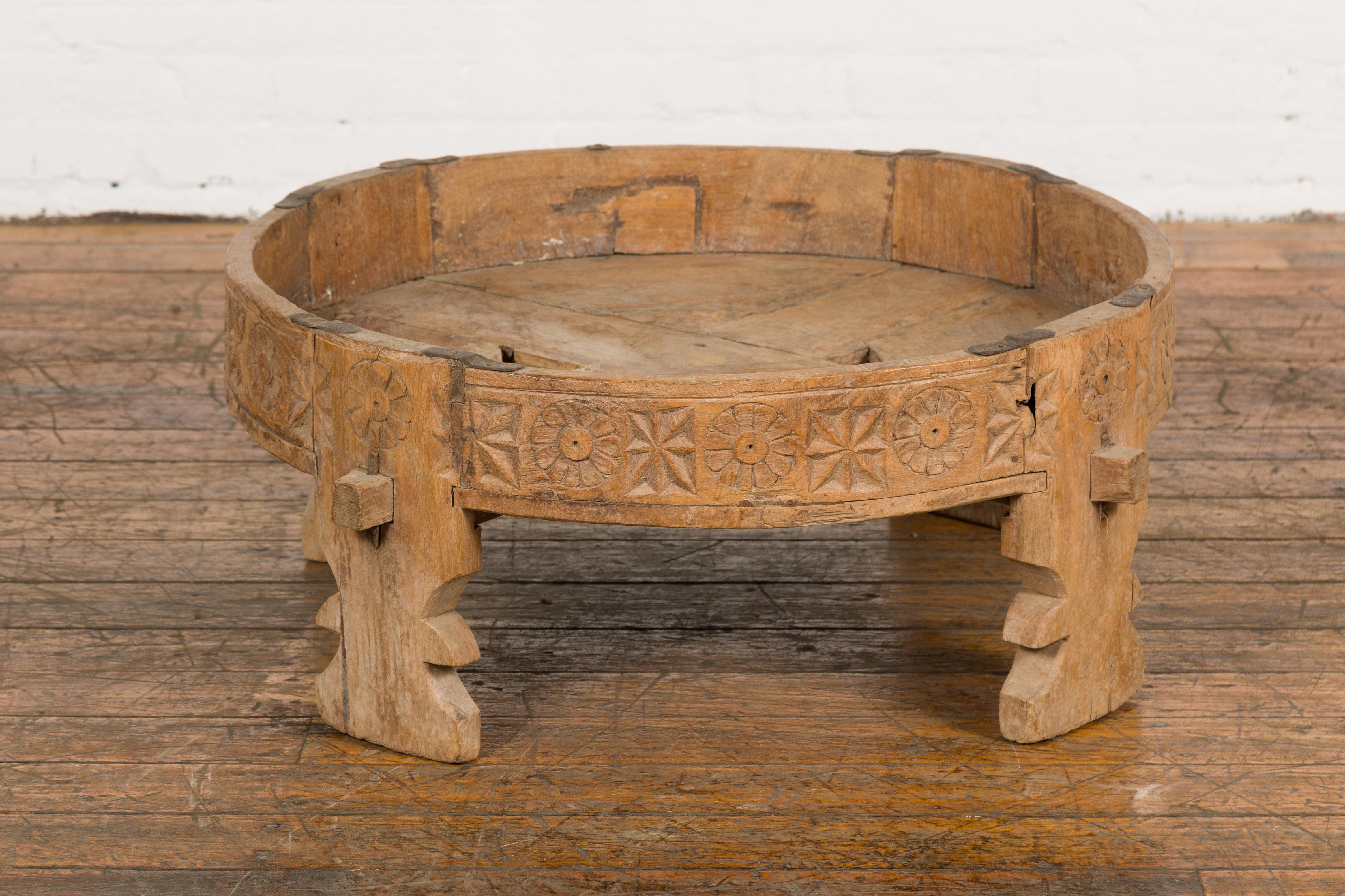 Table de broyeur Chakki rustique d'Inde tribale du début du 20e siècle avec des motifs géométriques sculptés à la main, des pieds sculptés et une patine vieillie. Créée en Inde dans les premières années du 20e siècle, cette table de broyage est