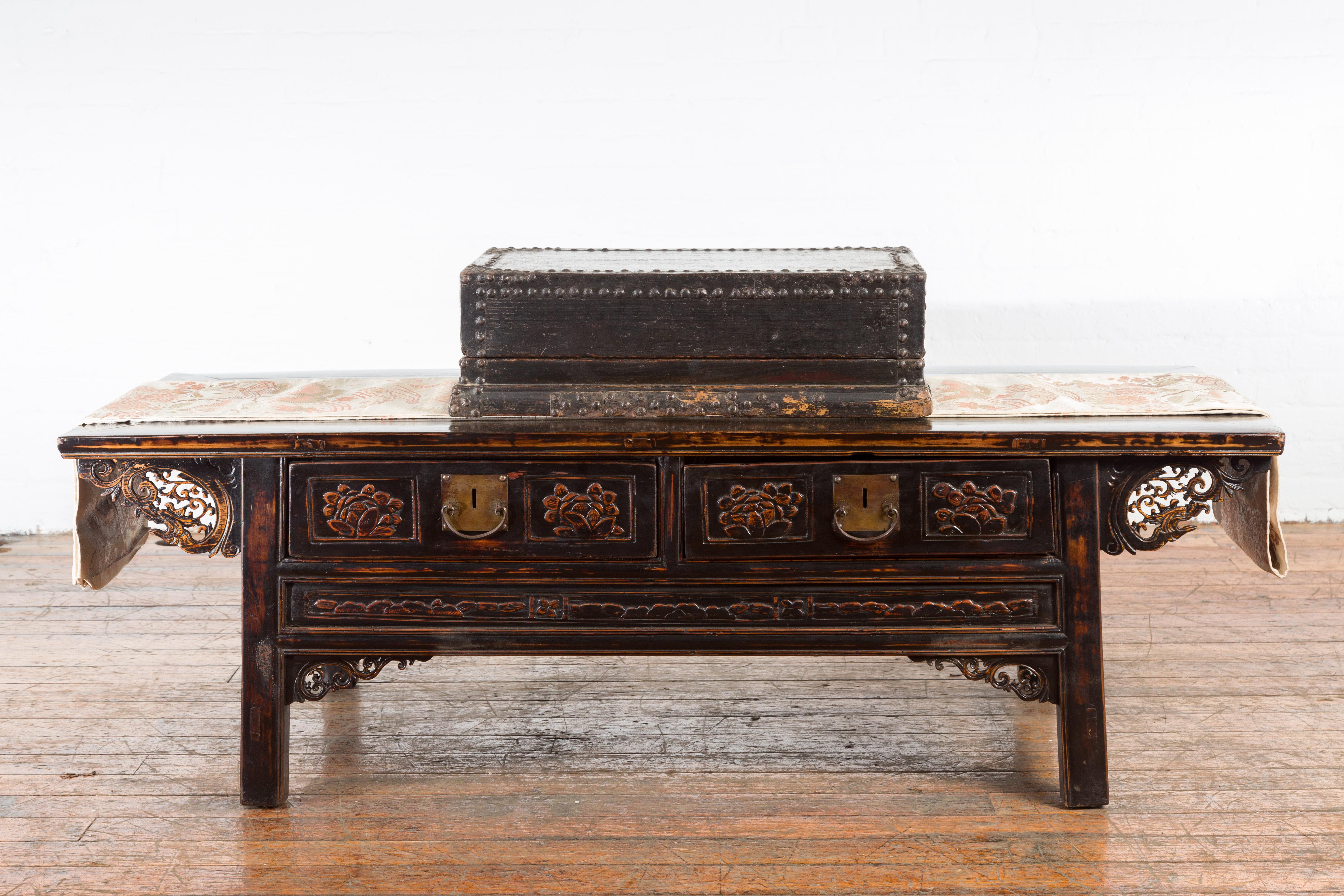 An Indian antique black box from the 19th century with iron nailheads and braces, carved wooden base and rustic patina. Created in India during the 19th century, this box features a linear silhouette perfectly complimented by a black patina accented