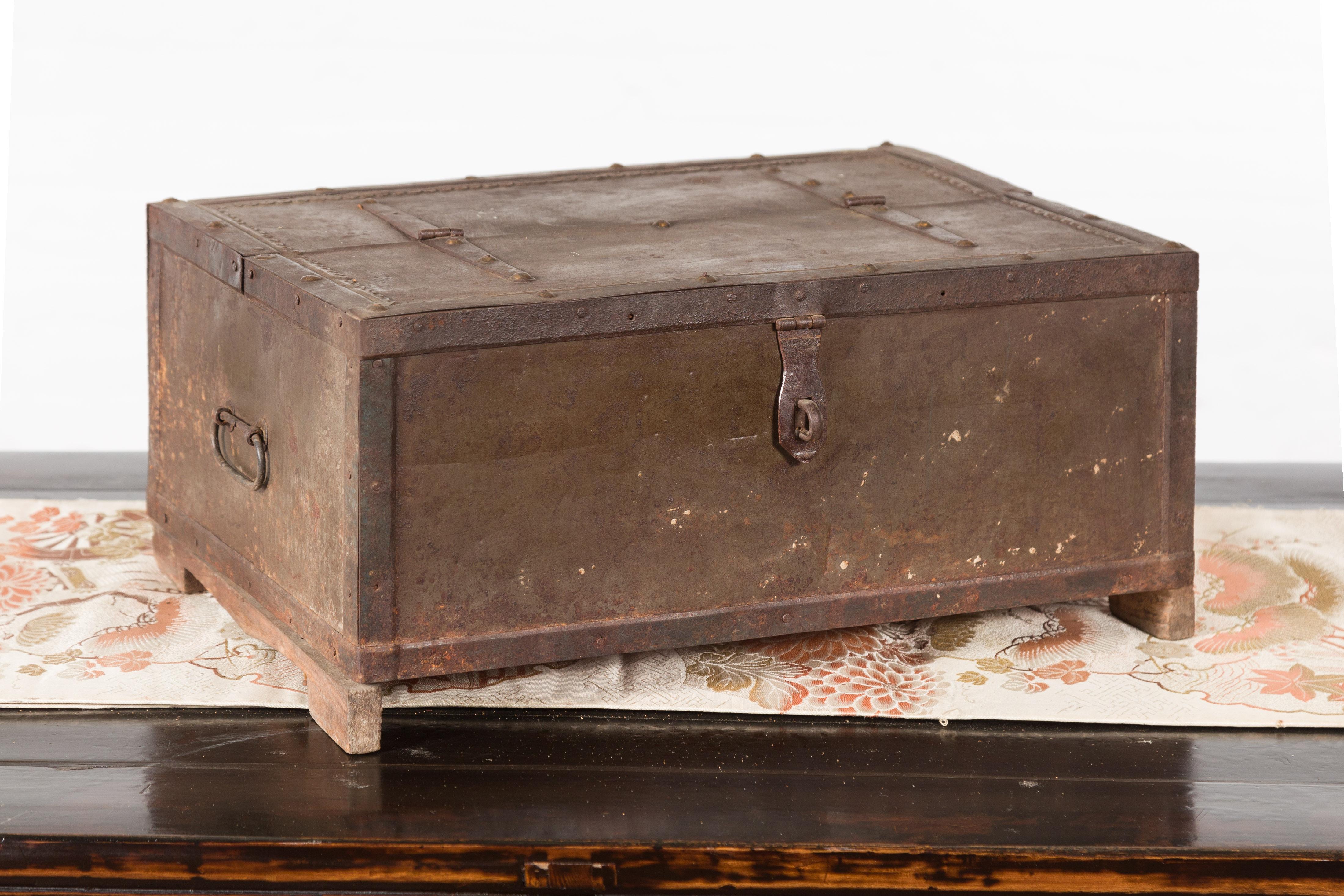 An Indian antique box from the 19th century with metal sheathing and bracketed base. Created in India during the 19th century, this antique box features a linear silhouette made of metal sheathing. Resting on a wooden bracketed plinth and boasting a