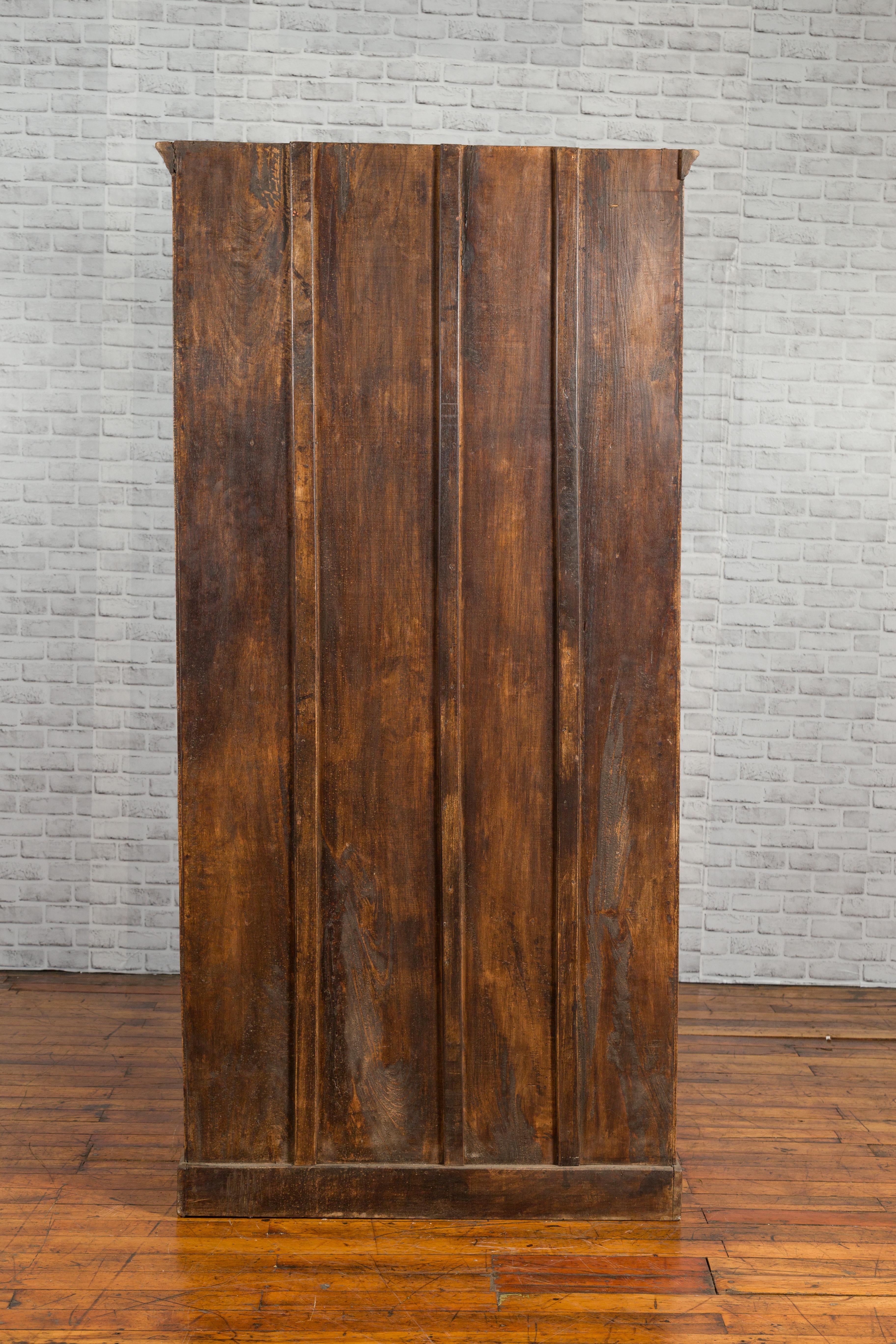 An Indian 19th century carved sheesham wood cabinet from Gujarat, with arching doors and iron hardware. Created in Western India during the 19th century, this this tall cabinet is made with a typical Indian wood called sheesham wood, which is