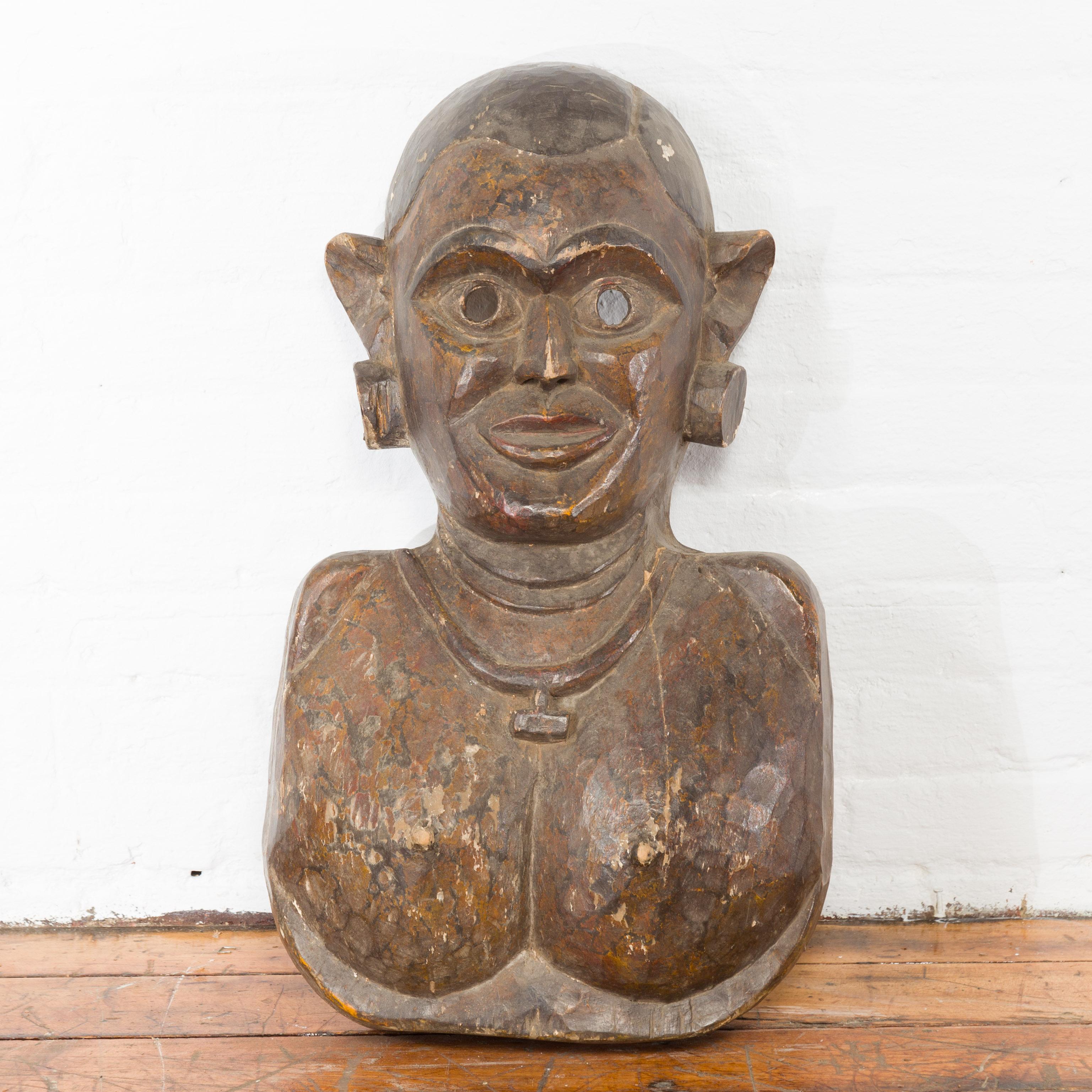 Our 19th century antique ceremonial wooden mask is from Jaipur, the capital of Rajasthan in India. The bust form mask features the woman from chest up with large earrings and necklace while her ears protrude from the sides of the antique wooden