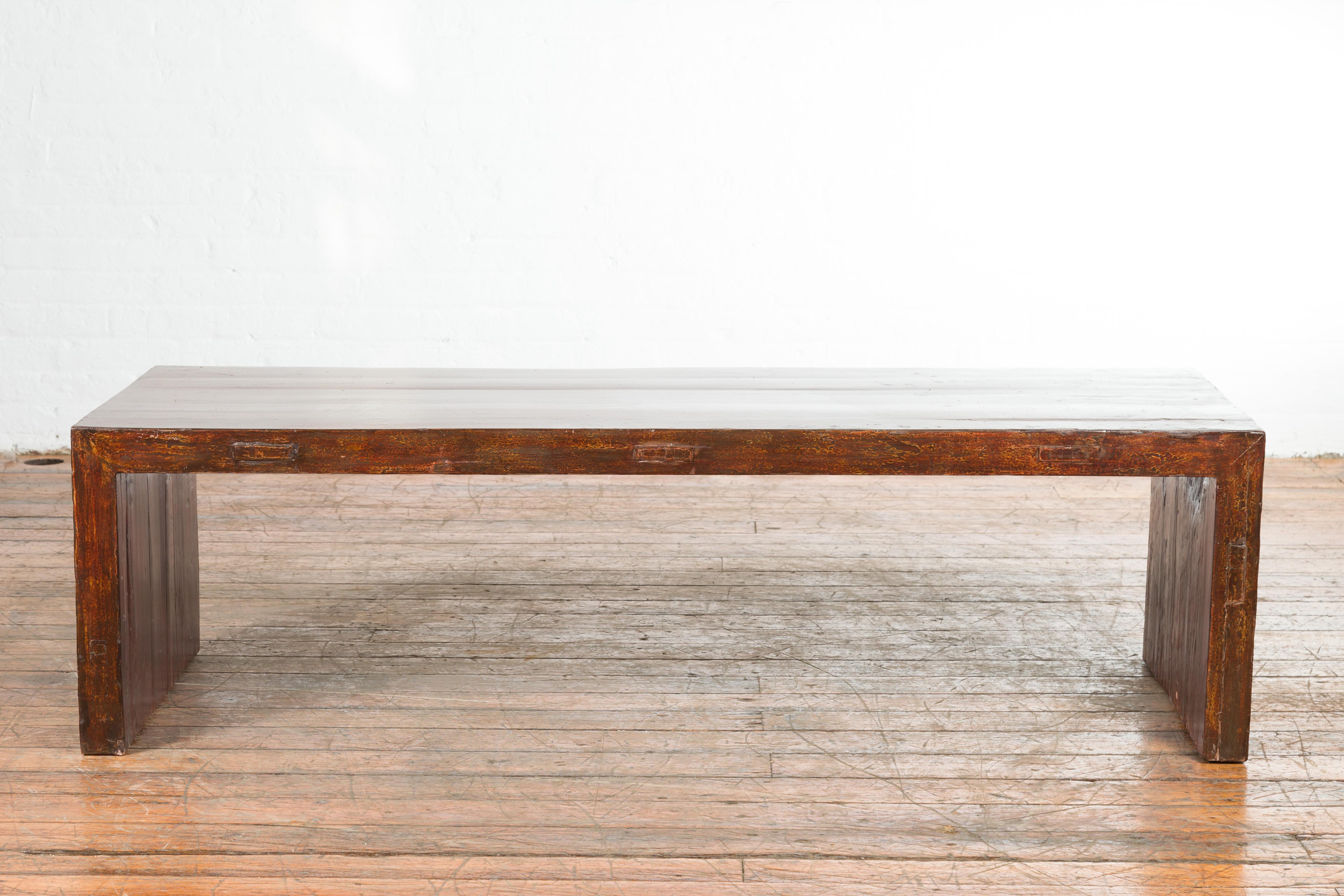 An Indian antique low altar console table from the 19th century, with underglaze snake skin pattern. Created in India during the 19th century, this low altar table features a rectangular top sitting above a linear base made of two solid supports on