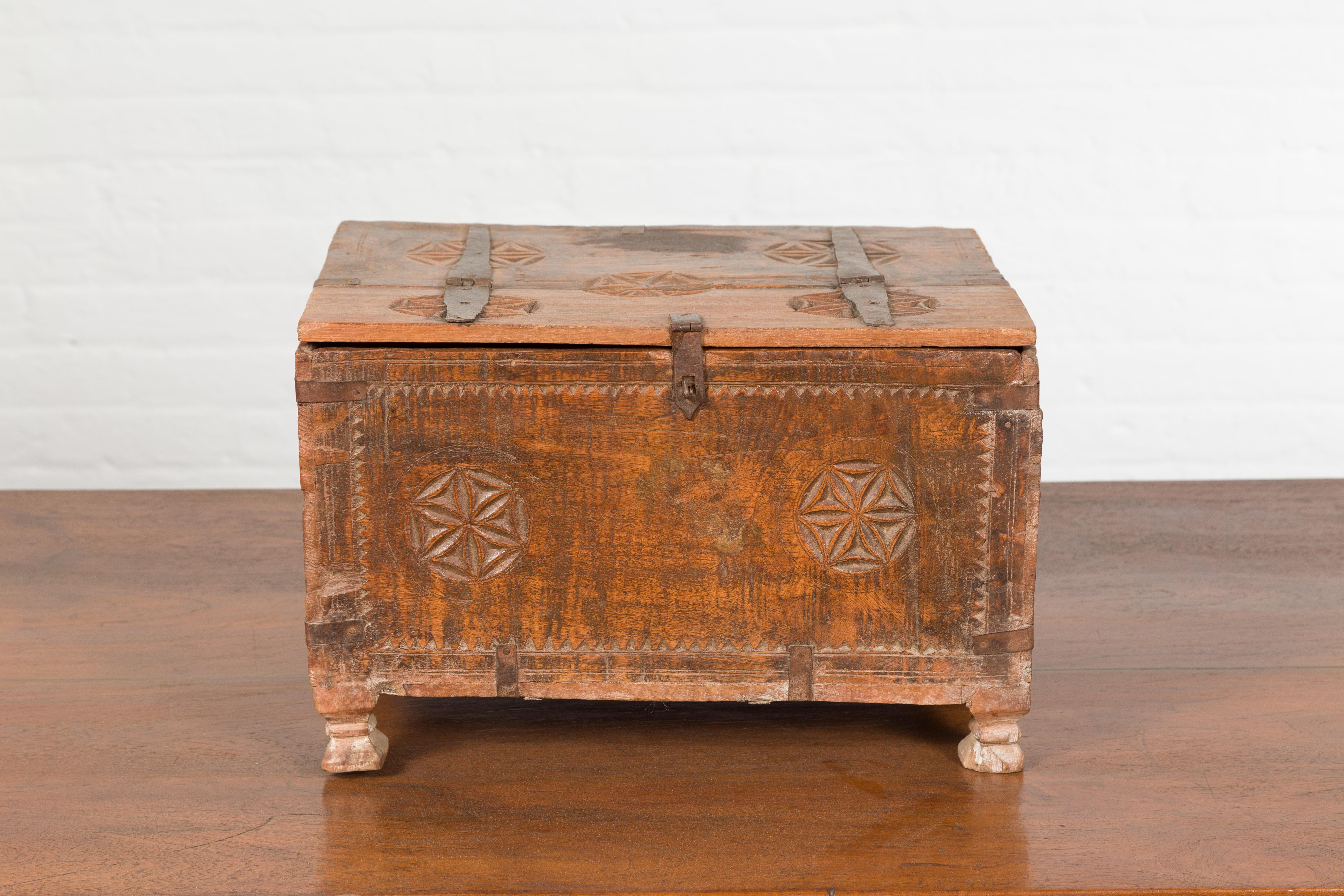 An Indian small wooden box from the 19th century, with iron hardware and carved rosacea. Created in India during the 19th century, this wooden box features a rectangular lid half opening to reveal a small interior. Accented with iron details and