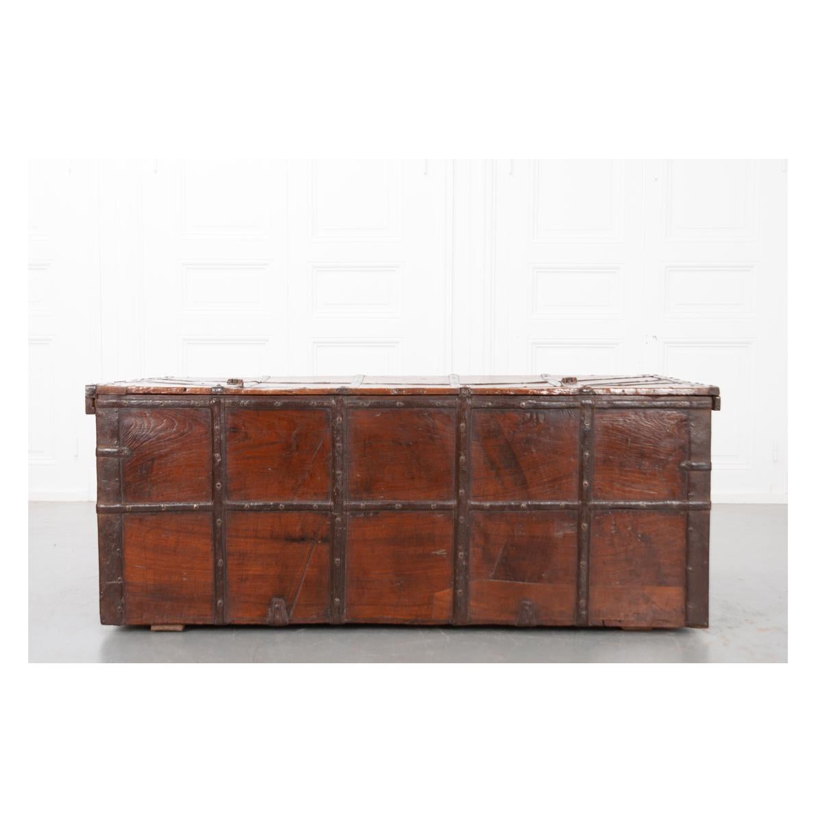 This 19th century, Anglo-Indian solid teak trunk with original iron bindings has aged beautifully. It has a striking patina with fantastic texture and grain. The hinged top has two forged iron hasps that would have been pinned close with an iron or