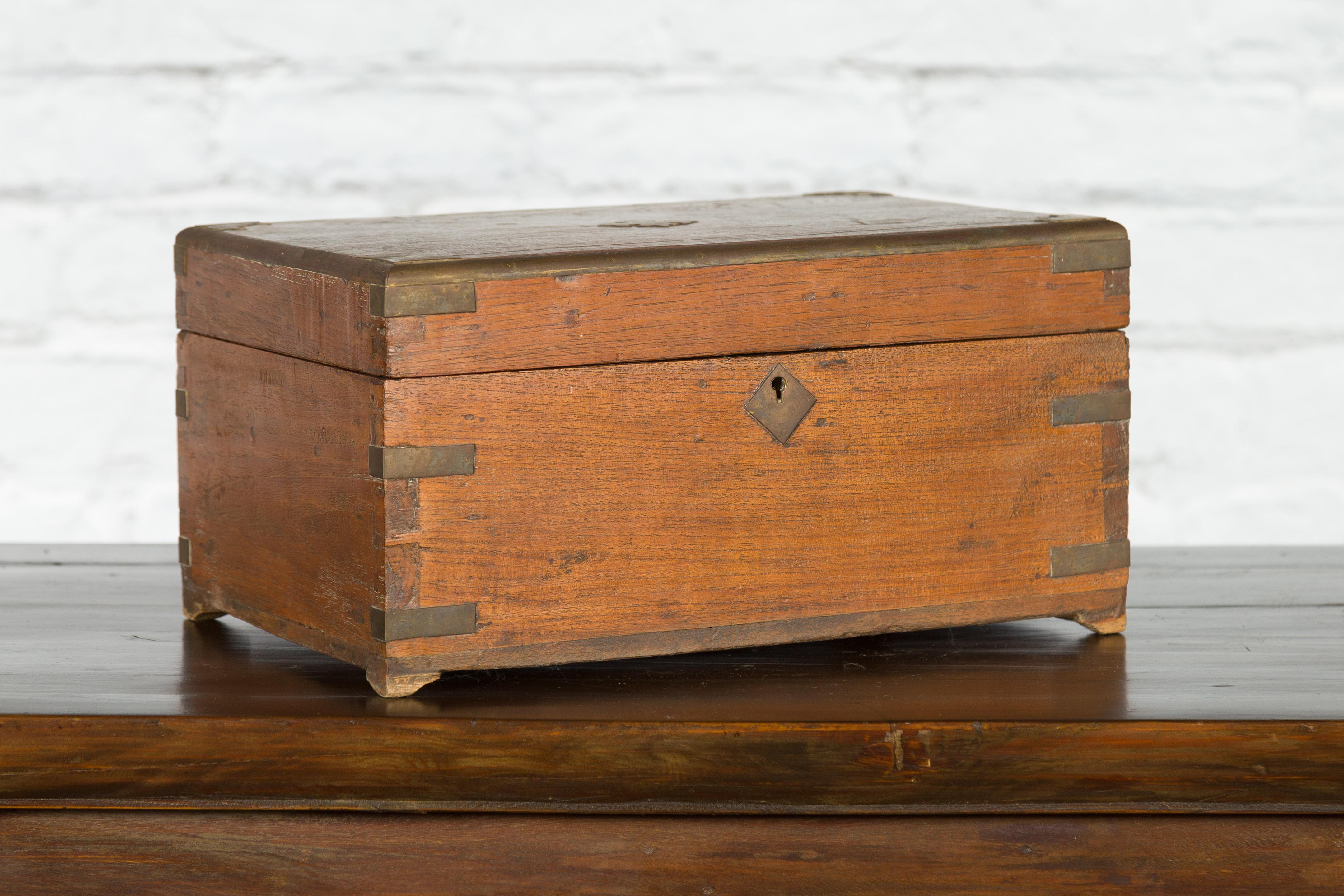 An antique Indian handmade jewelry box from the 19th century with brass hardware, bracket feet and partitioned interior. Created in India during the 19th century, this hand-crafted decorative treasure chest can be used as a jewelry box, stationary