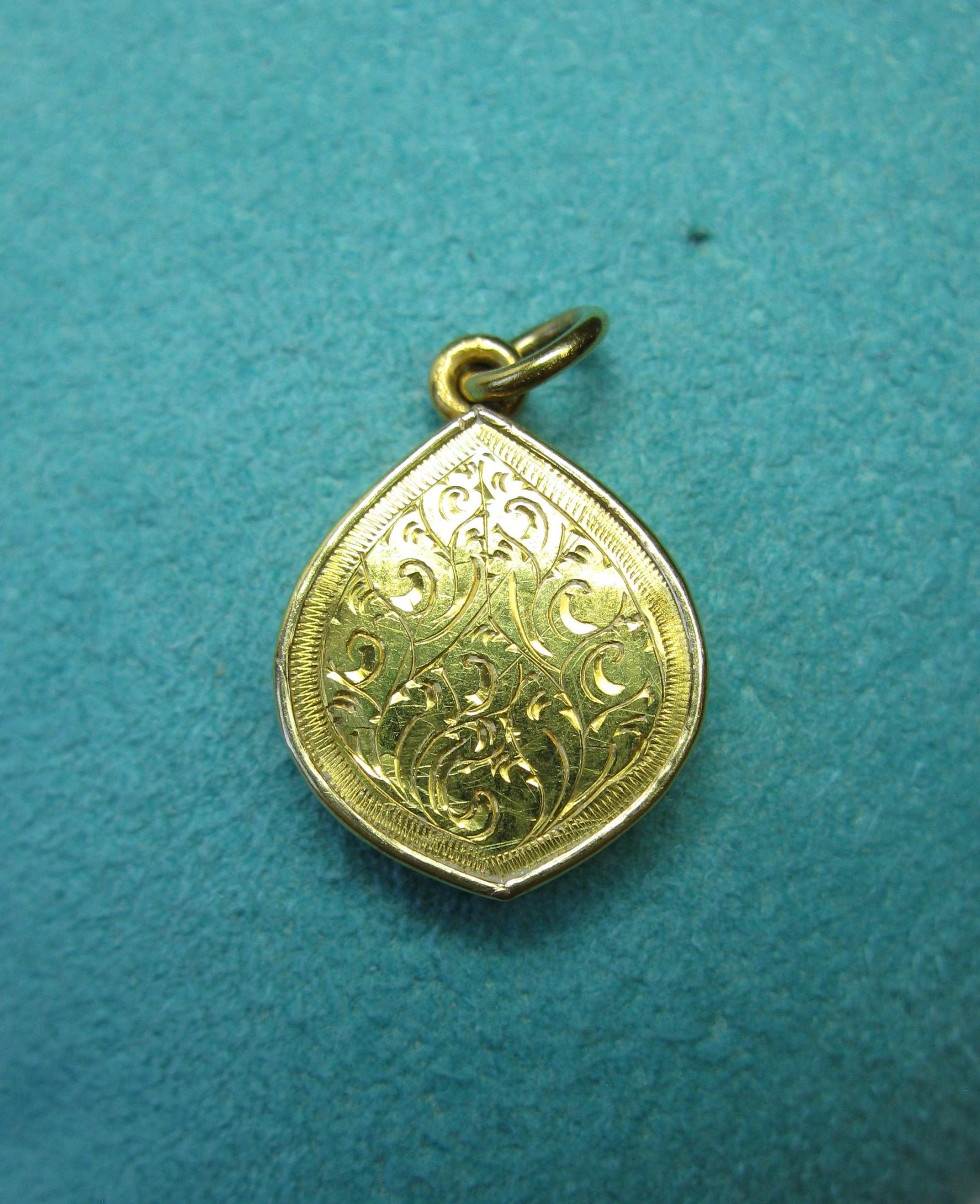 A wonderful Indian Jewel Pendant or Charm in 22 Karat Gold with a central Cameo Image of the God Durga or Buddha.  The image is beautifully carved in a raised cameo style on a black stone.  The image is surrounded by an engraved border in 22 Karat