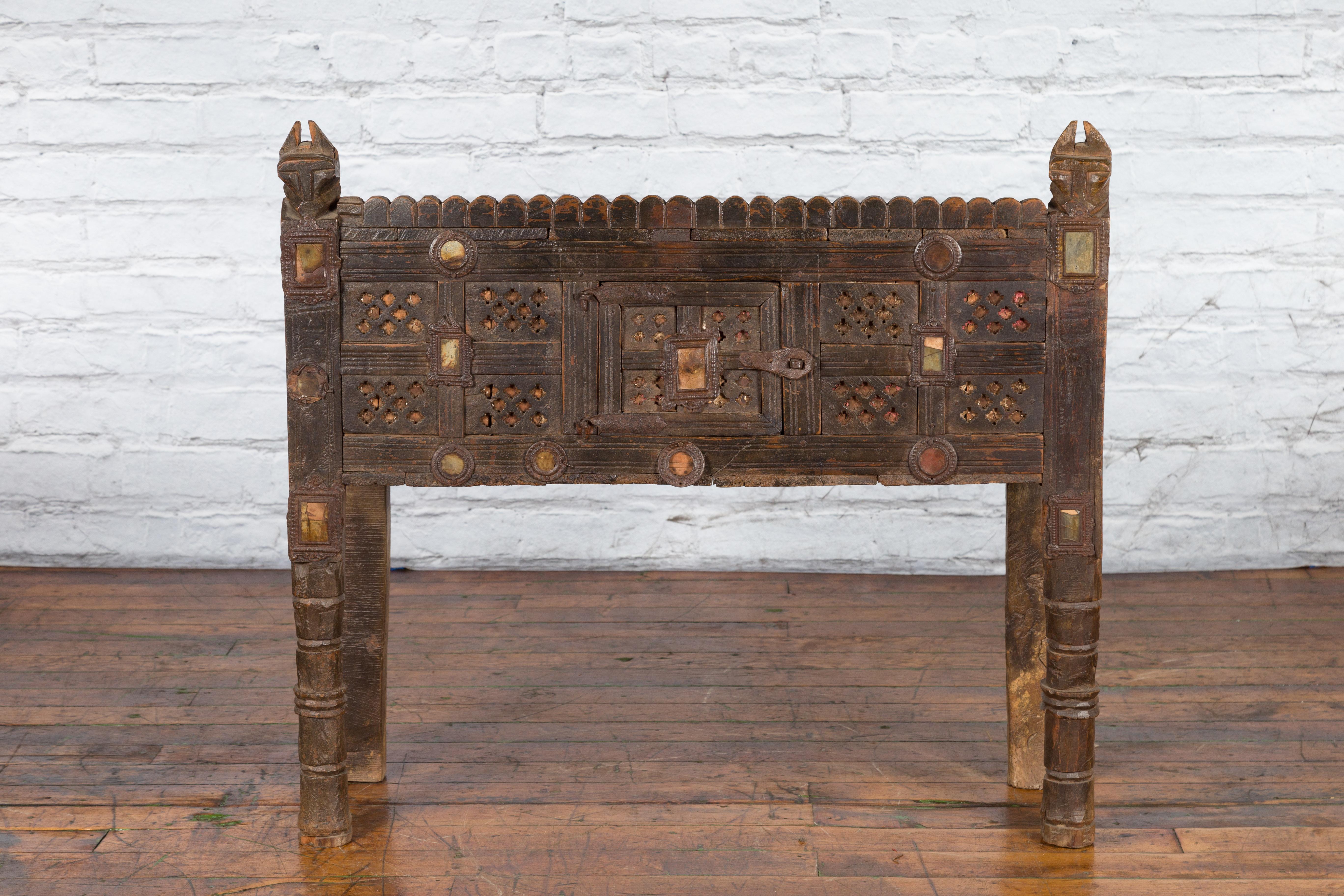 An antique Indian Damachiya bridal cabinet from the 19th century, with geometric patterns, inlaid mirrors and carved stylized horse heads. Created in India to store bridal dowries, this Damachiya cabinet captures our attention with its intricate