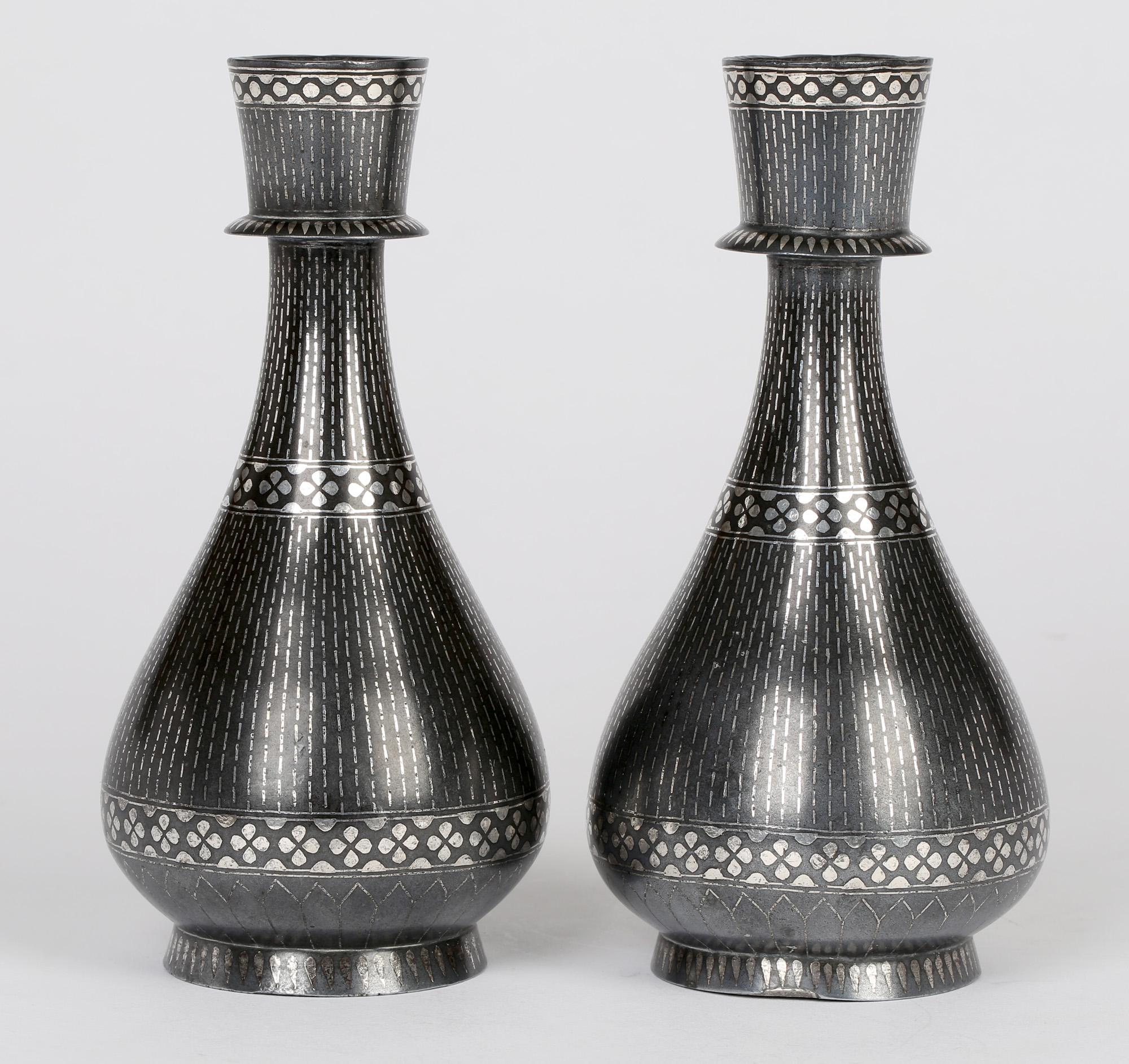 A very fine pair antique Indian Bidri Ware vases of teardrop shape with linear and floral petal designs in silver overlay probably dating from the late 19th century. The vases stands raised on a rounded pedestal foot with a tear drop shaped body,