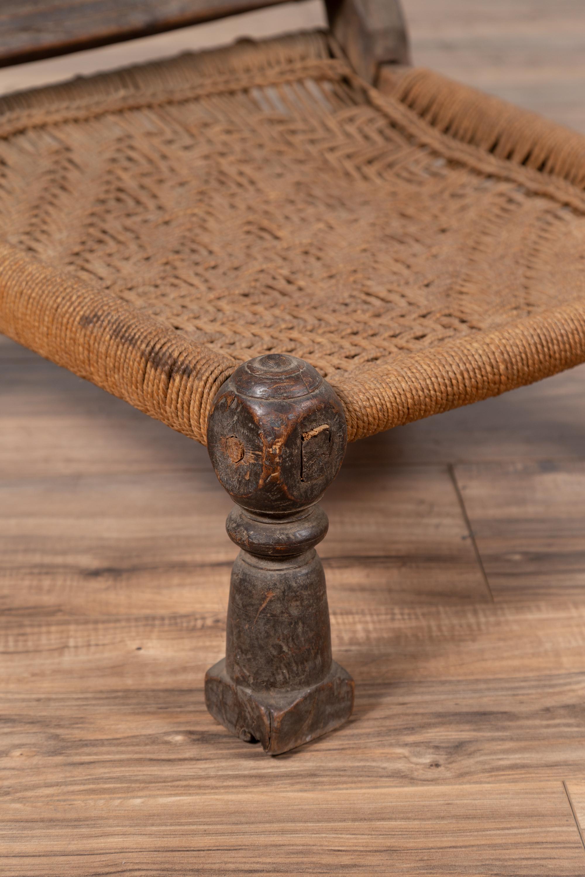Indian Antique Rustic Low Seat Wooden Chair with Carved Rosettes and Rope Seat For Sale 2