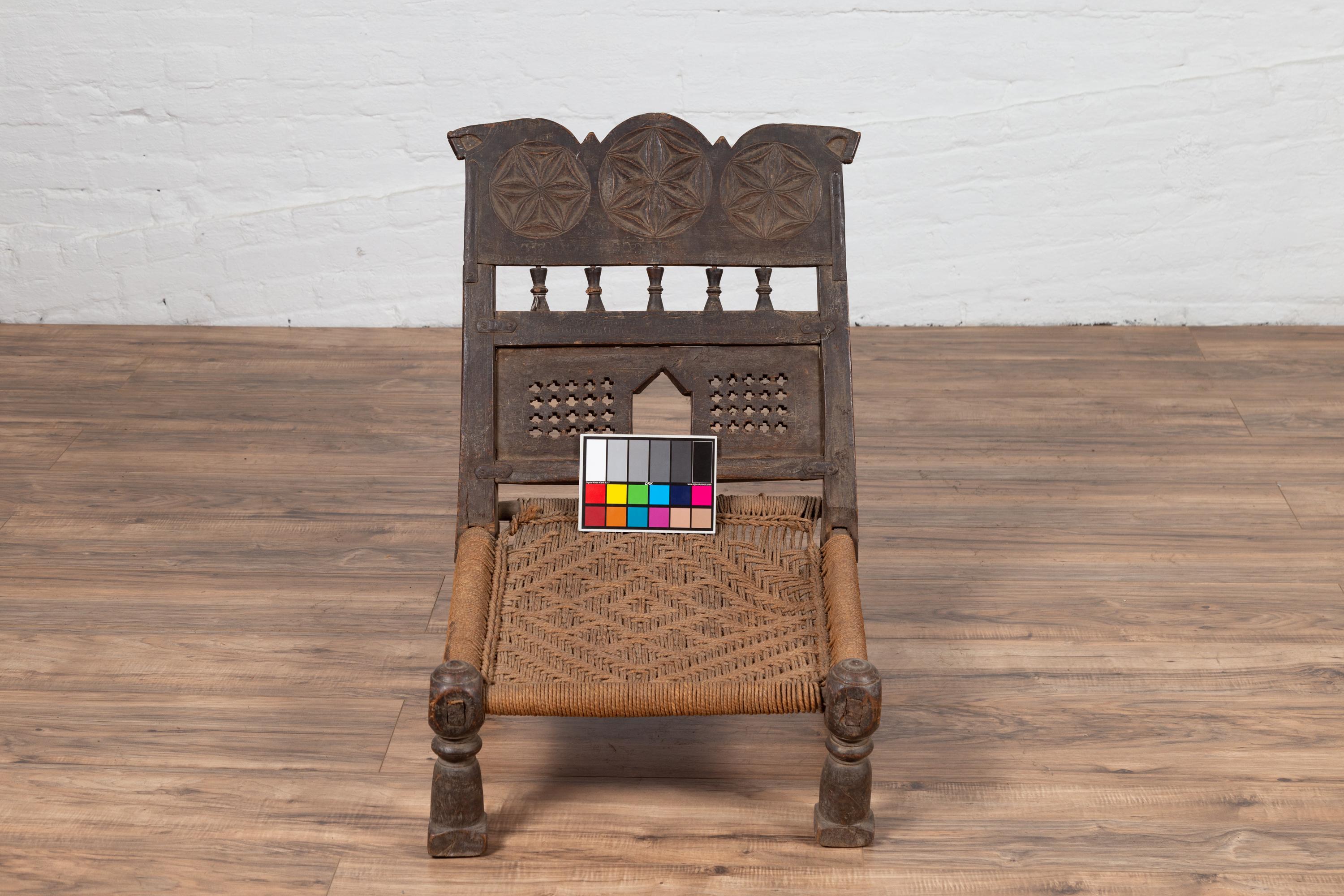 Indian Antique Rustic Low Seat Wooden Chair with Carved Rosettes and Rope Seat For Sale 8