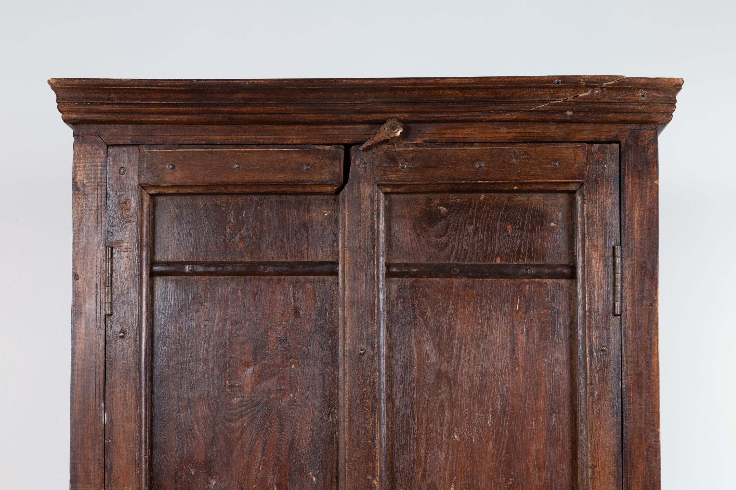 20th Century Indian Antique Wooden Armoire with Paneled Doors, Metal Braces and Aged Patina