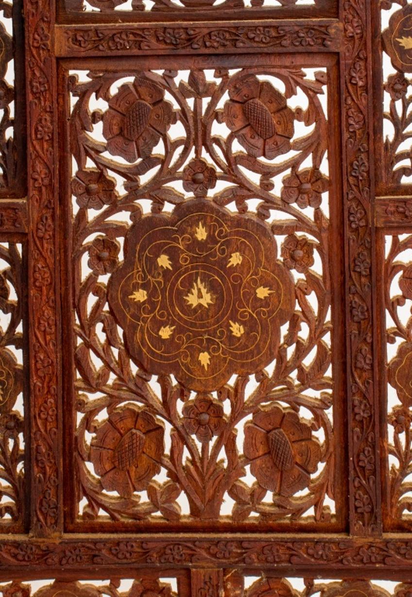 Indian bone-inlaid teakwood four panel screen, with ornately carved geometrically divided surface, the scrolling floral designs picked out in bone. Measures: 67