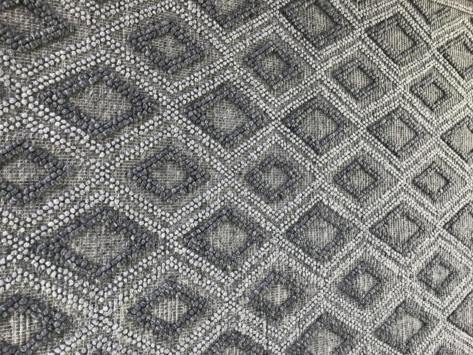 Design meets texture in this dynamic contemporary Indian braided rug with diamond pattern. The versatile gray-scale tones can provide companion piece for a similar mono-chromatic scheme or a neutral base to make colors pop. Braiding adds a