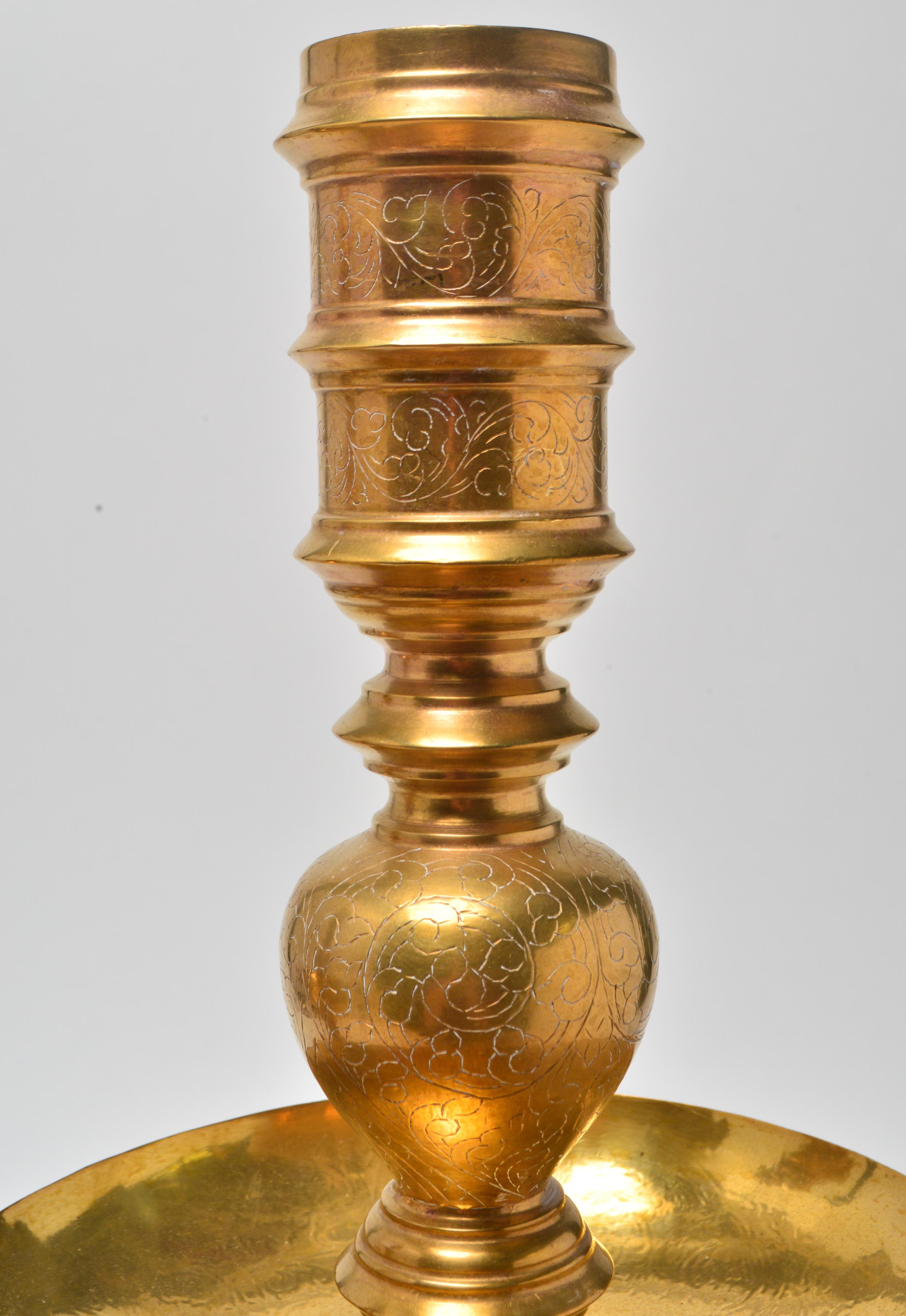 Indian pair of large engraved brass candlesticks with a large central bobeche each. The pair is in great vintage condition with age-appropriate wear.