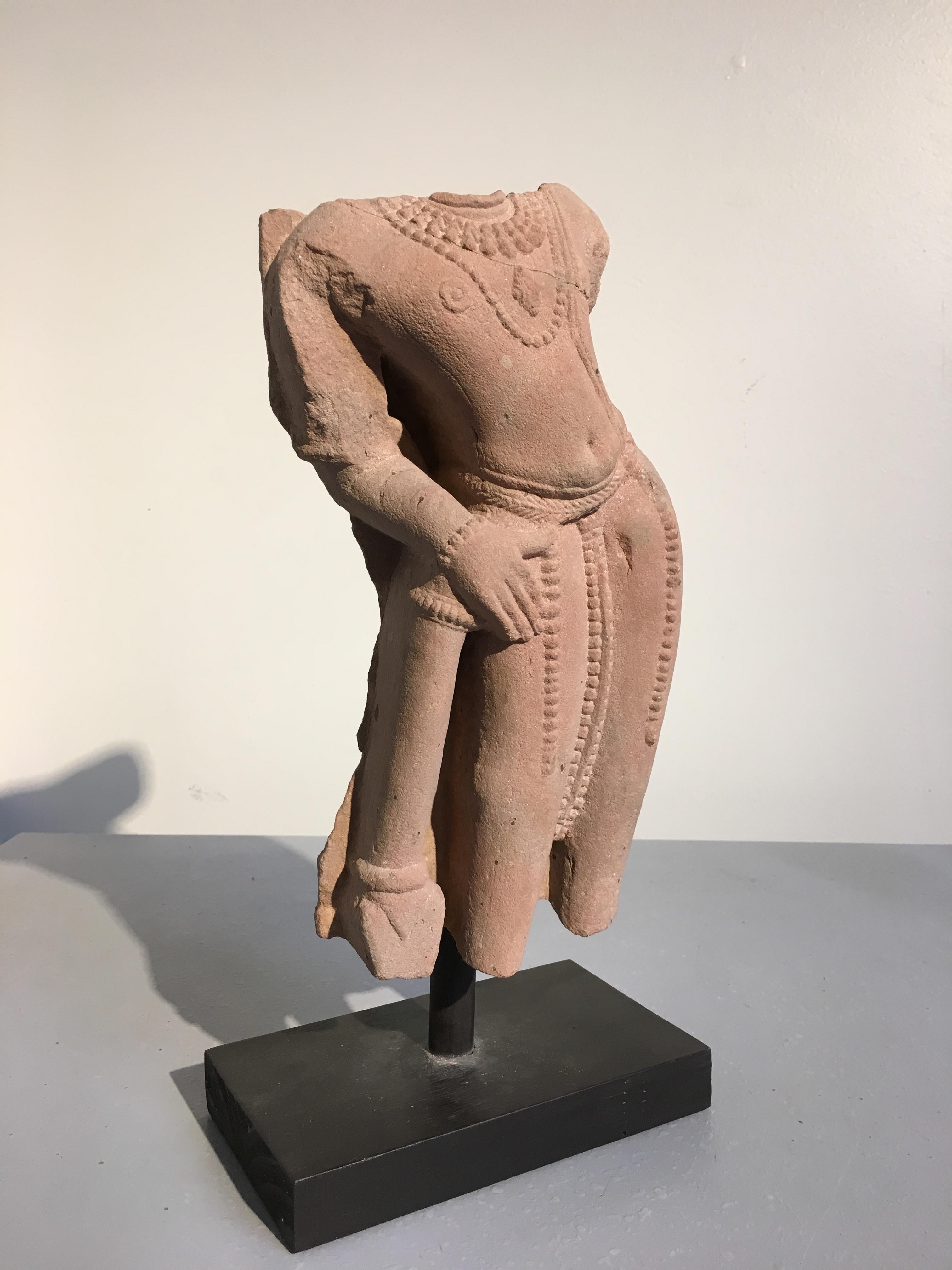An alluring fragmentary sculpture of the Hindu god Vishnu, carved from pink sandstone, Madhya Pradesh, circa 10th-11th century.

Carved from a pink sandstone, Vishnu the Preserver is portrayed in an exaggerated tribhanga (thrice bent) pose. His