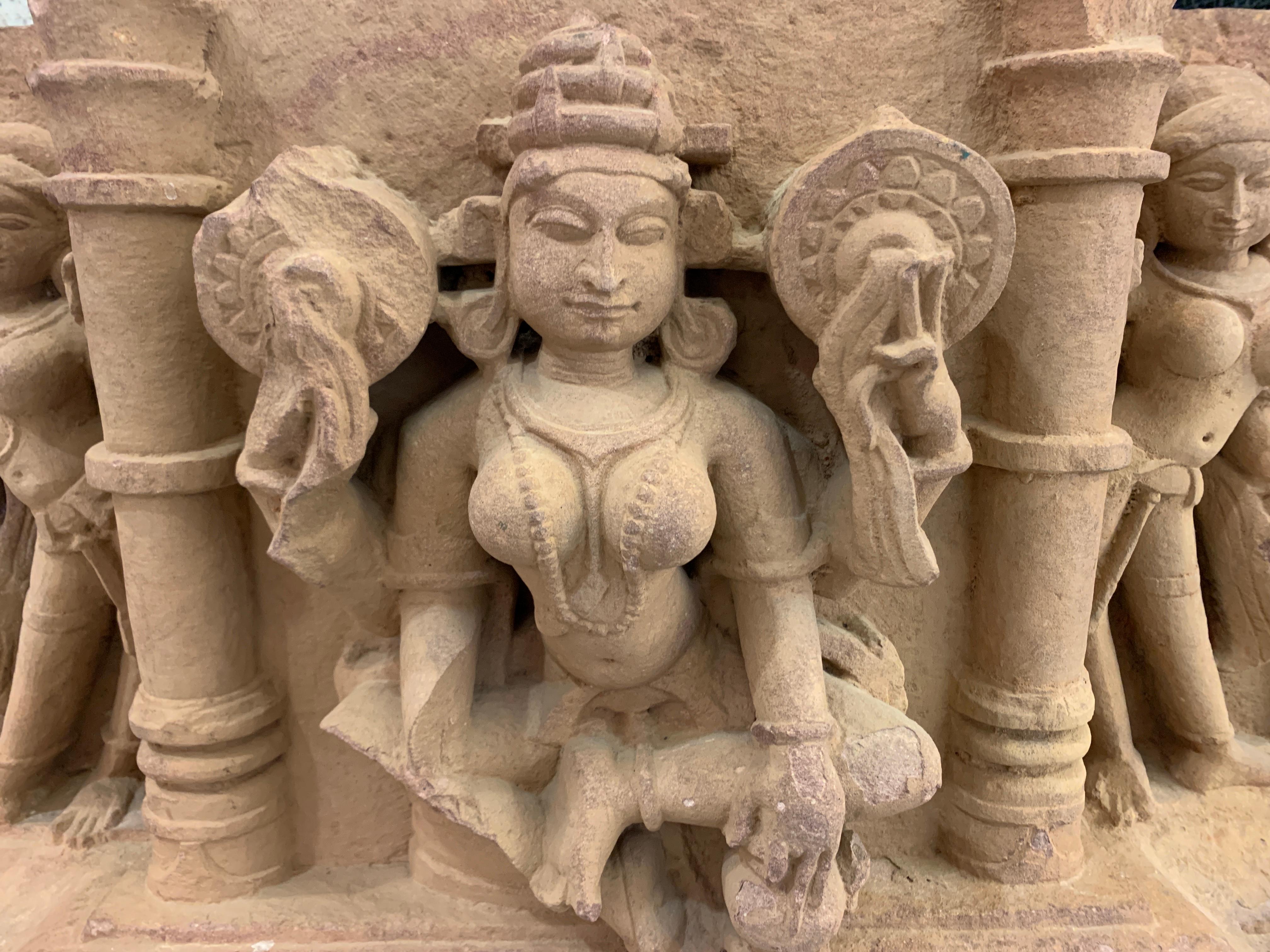 A large and impressive Indian carved sandstone architectural frieze featuring a central image of the Hindu goddess Lakshmi flanked by two attendants, Central India, 10th-11th century.
Lakshmi, the Hindu goddess of love, wealth and prosperity, is