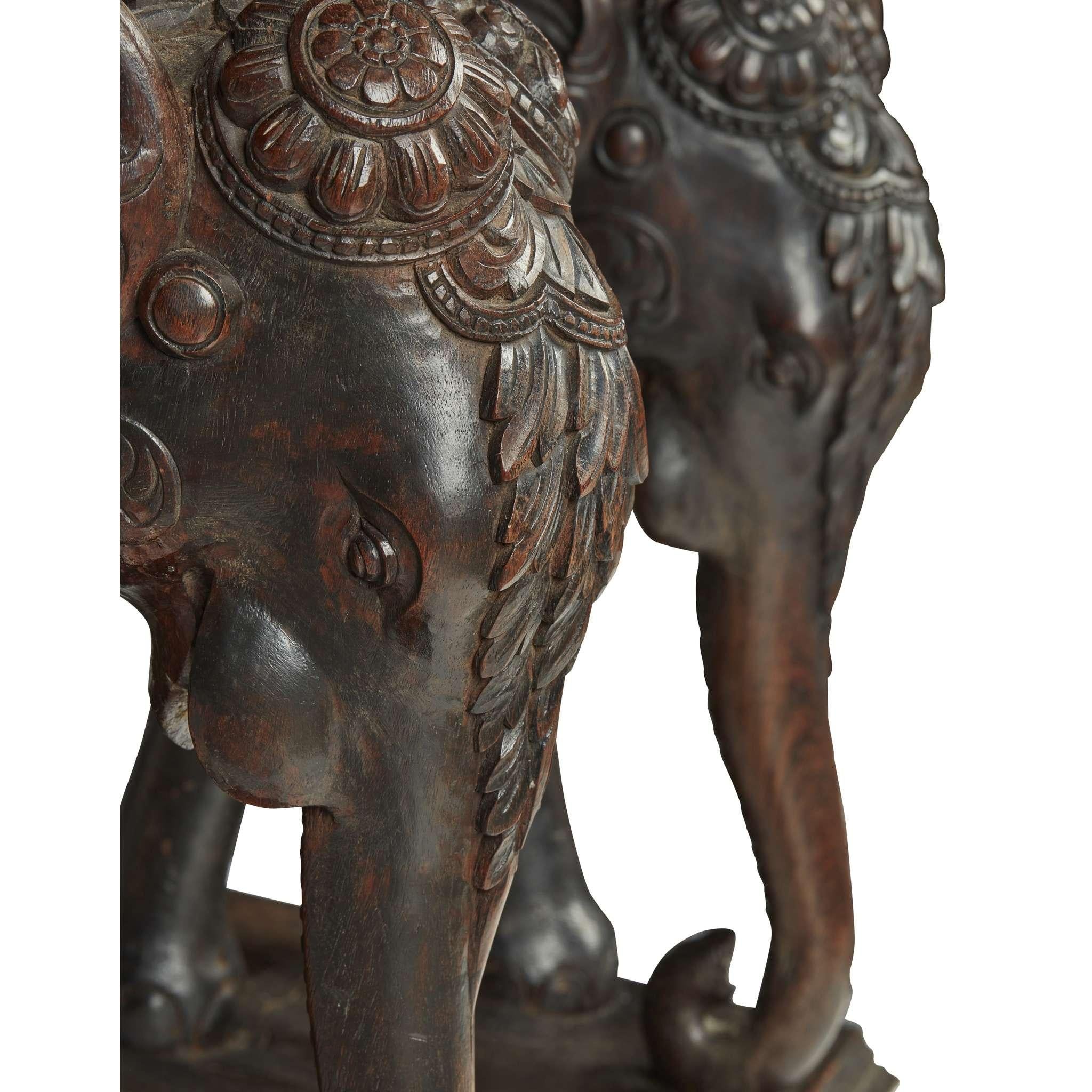 Table d'appoint en teck indien sculpté représentant un éléphant, début du 20e siècle

Le plateau rectangulaire est orné d'une bordure sculptée de feuilles et centré par un rondeau d'éléphant sculpté, soutenu par une paire d'éléphants sculptés sur