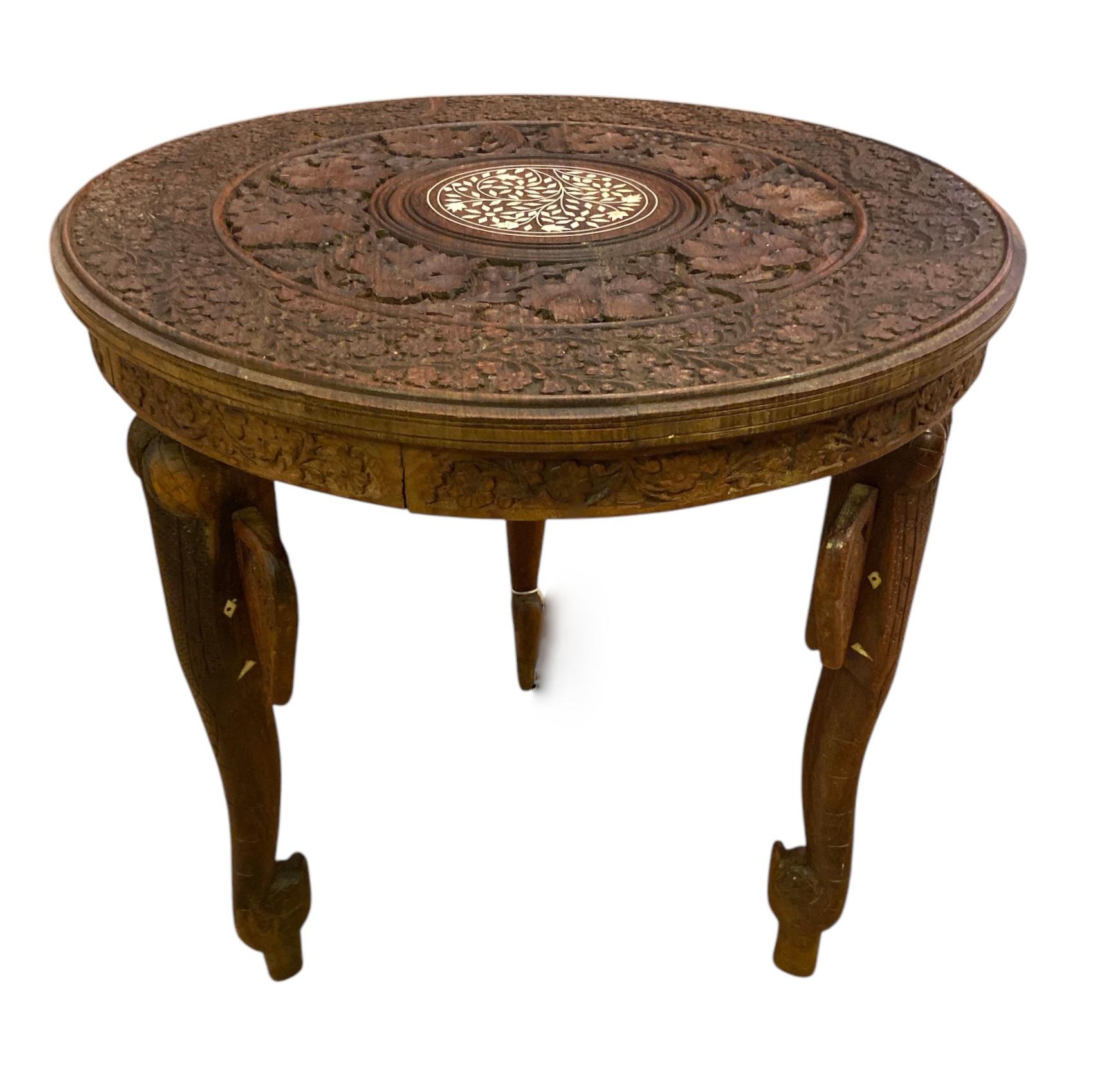 Indian coffee table with elephant-heads legs shaped like elephant heads.
Hand-carved top with detailed grapes and grape and grape leaves.
In de centre an image of flowers with inlaid bone. 