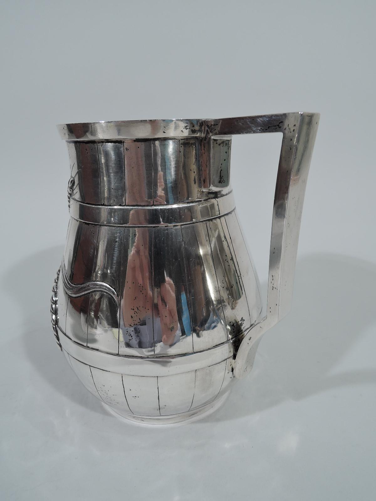 Indian Colonial silver beer barrel mug. Made by Allan & Hayes in Calcutta, circa 1860. Incised staves and chased hoops entwined with fluid grain stalks forming asymmetrical cartouche (vacant). Bracket handle. Gilt interior. Maker’s stamp underside.