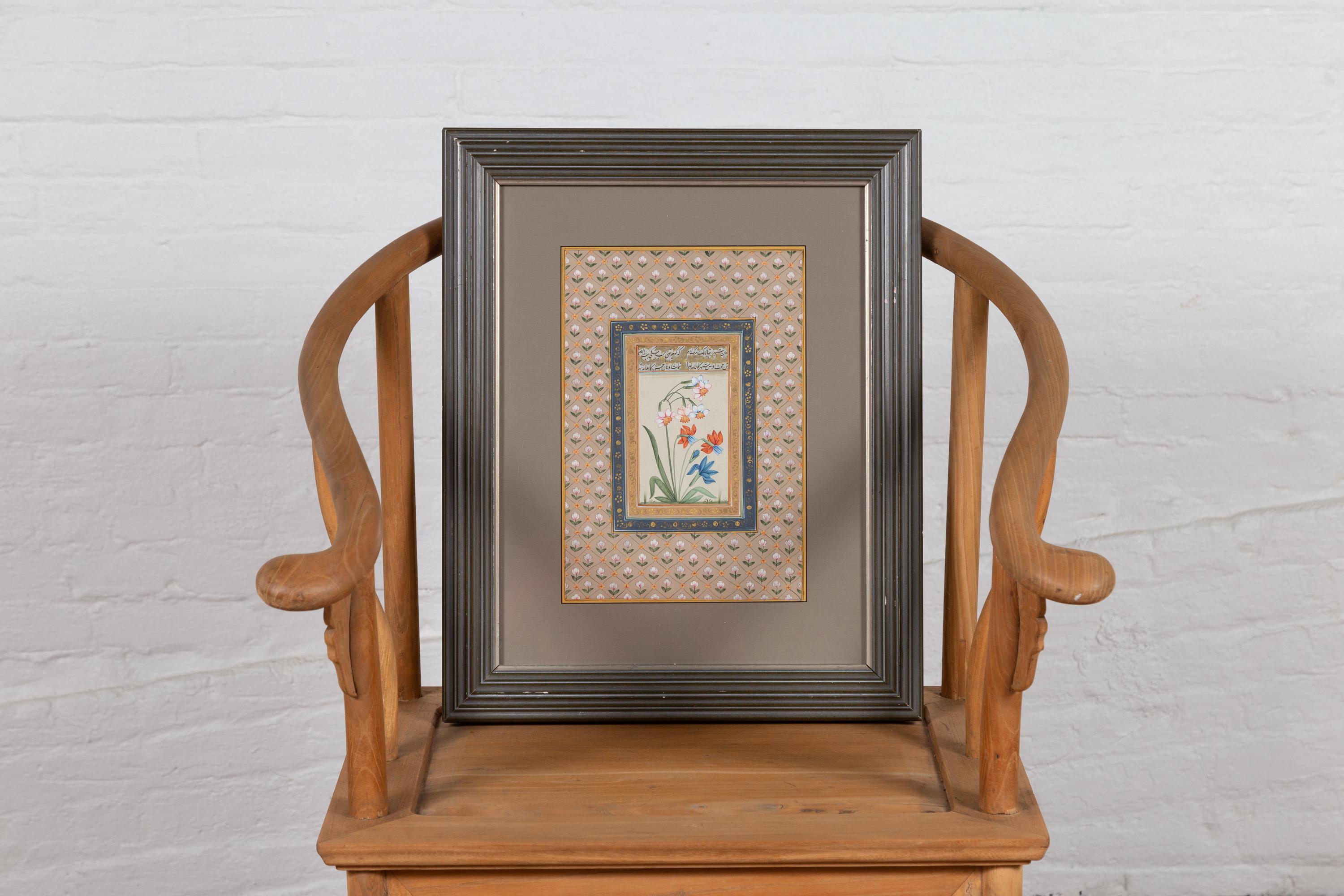 An Indian vintage framed still-life of vertical format from the mid-20th century, with white, orange and blue flowers topped with calligraphy. We have four frames available, priced and sold individually. Born in India during the mid-century period,