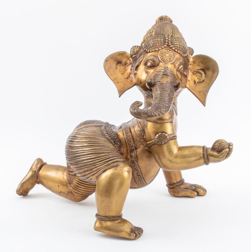 Indian gilt bronze statue sculpture depicting baby Lord Ganesh hold an orb in his right hand. 21