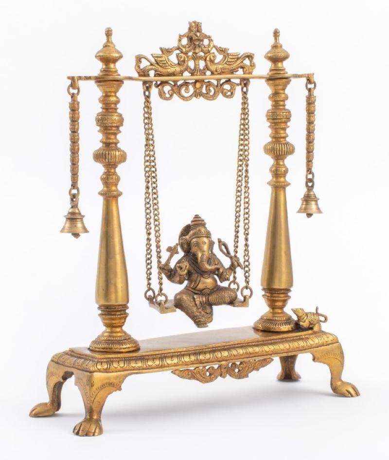Indische vergoldete Bronzestatue des hinduistischen Lord Ganesh auf einer Schaukel zwischen zwei Säulen und Glocken sitzend, überragt von einem Tympanon in Form von zwei Vögeln, die eine Fabelwesen-Maske einrahmen, montiert auf einem rechteckigen