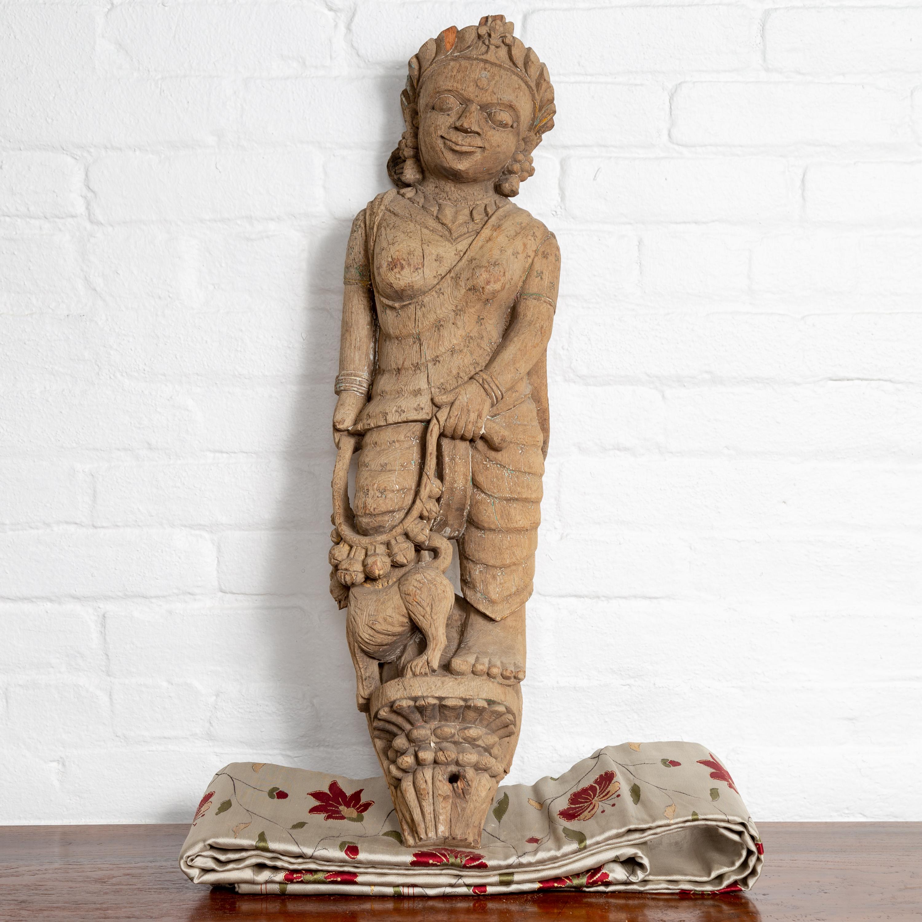 An Indian early 20th century hand carved architectural temple carving from Gujarat, depicting a woman and a feline. Born in the Western portion of India in the state of Gujarat, this exquisite hand carved temple sculpture features a woman and her