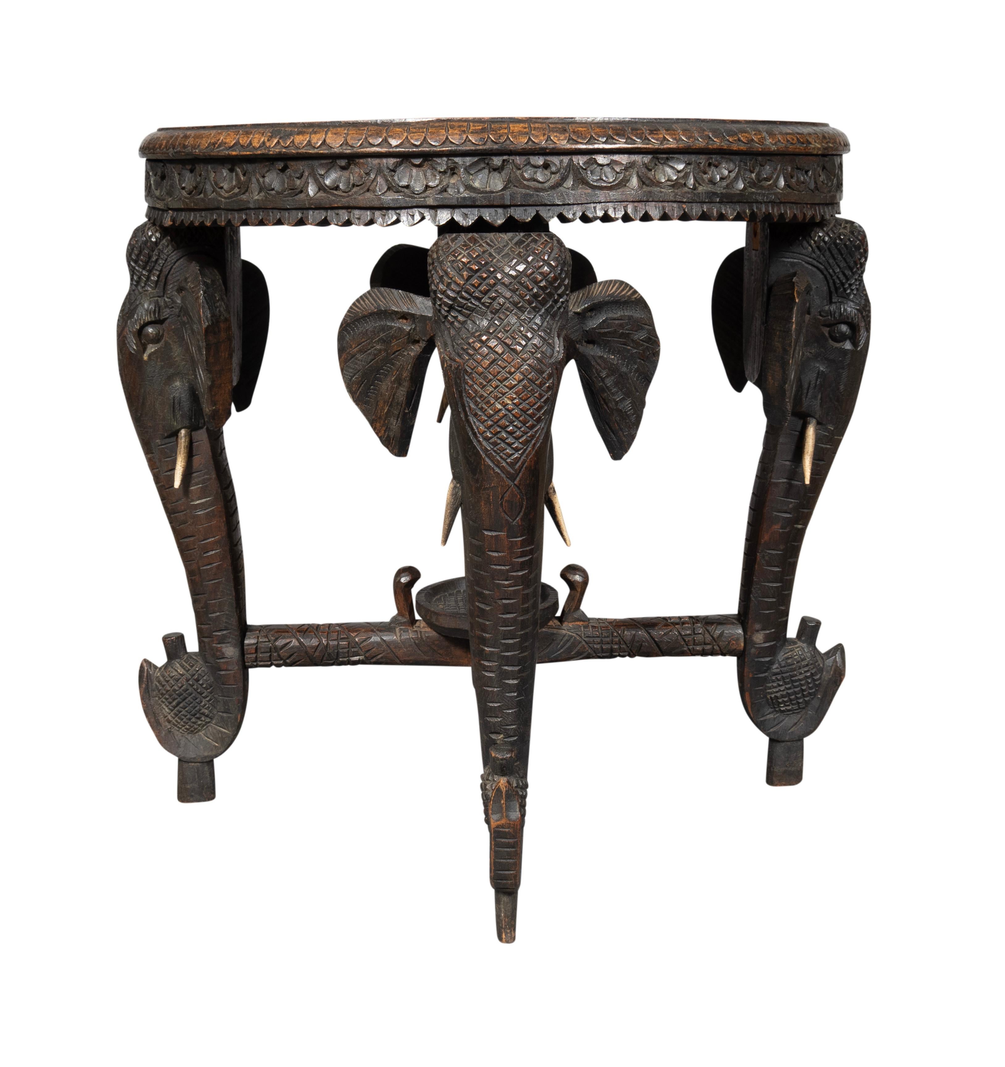Plateau circulaire avec bandeau extérieur sculpté et éléphant central sculpté. Tête d'éléphant et jambes du tronc. Brancard en forme de X.